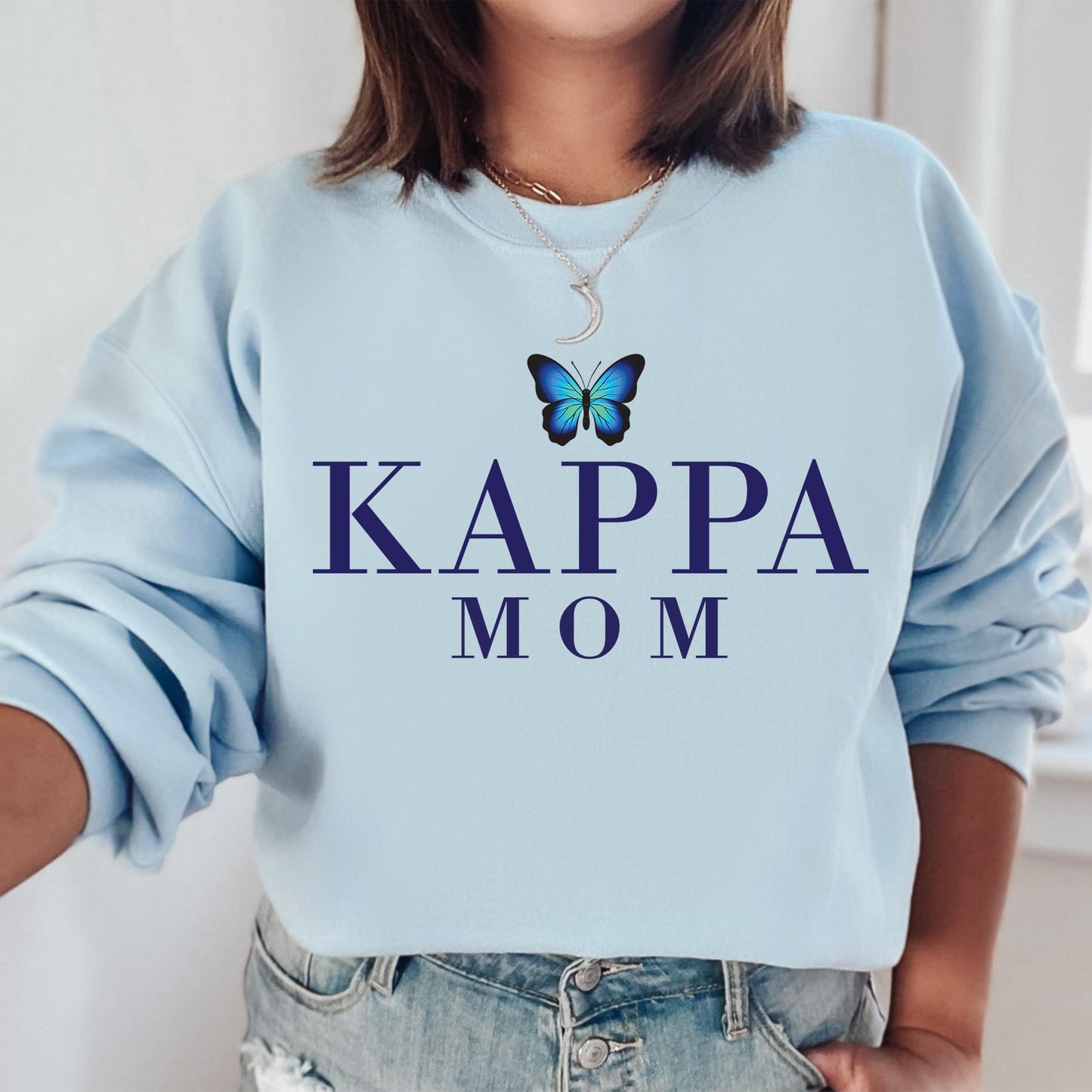 a woman wearing a sweatshirt that says kappa mom