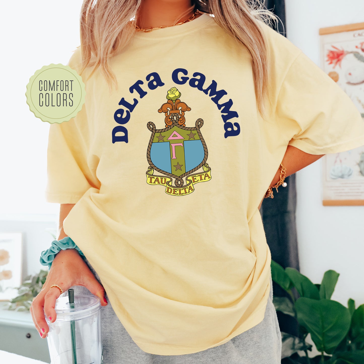 a woman in a yellow shirt is holding a drink