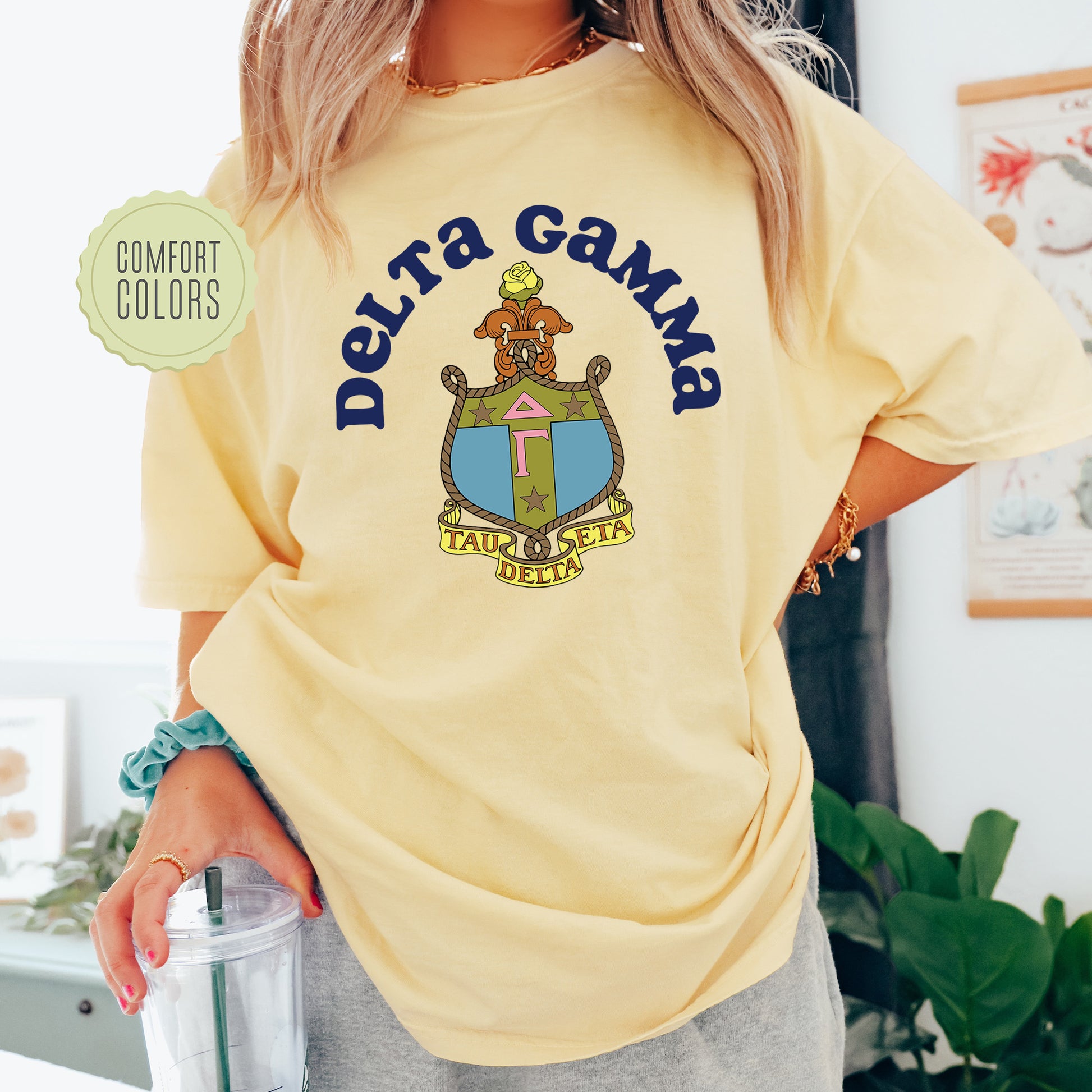 a woman in a yellow shirt is holding a drink
