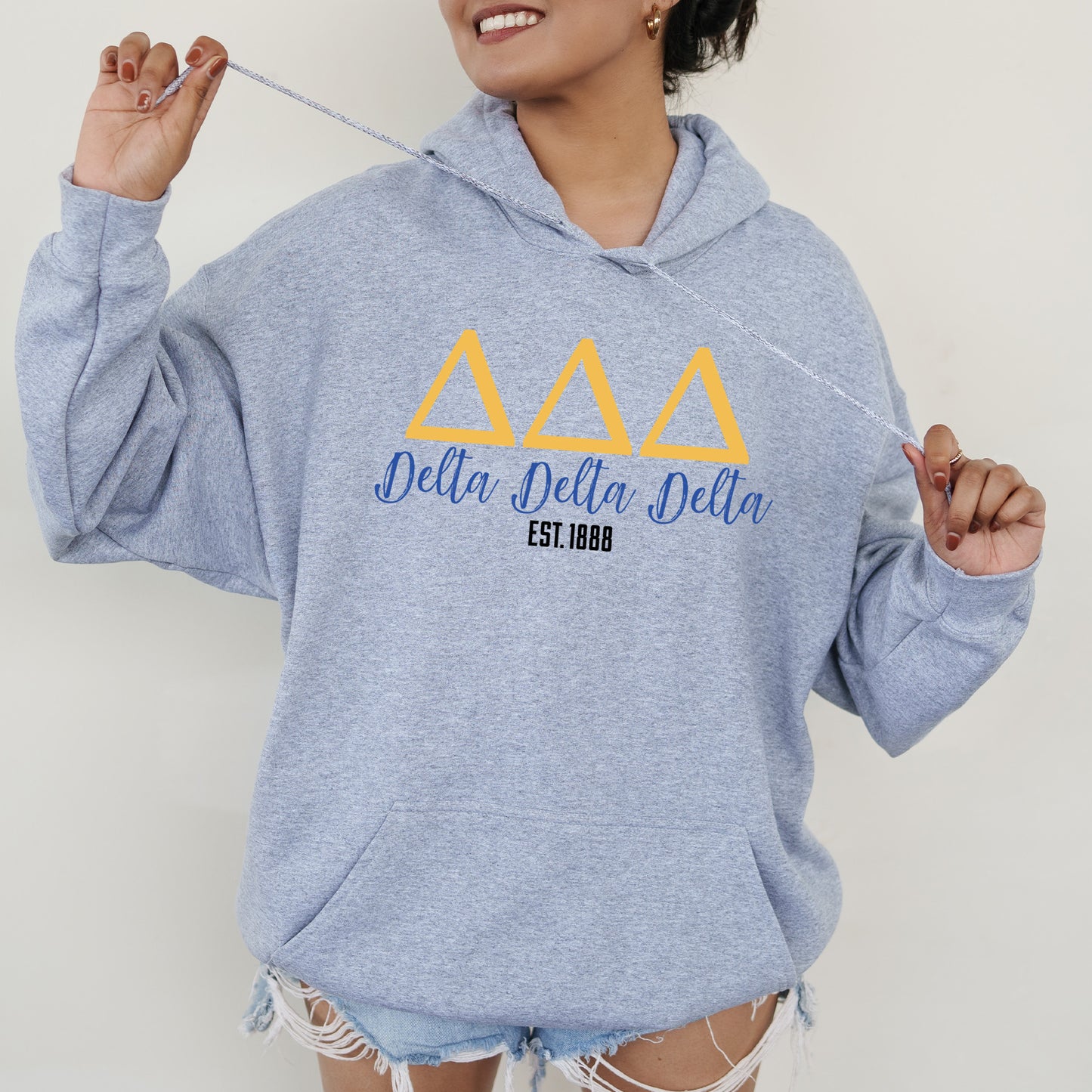a woman in a blue hoodie holding a toothbrush