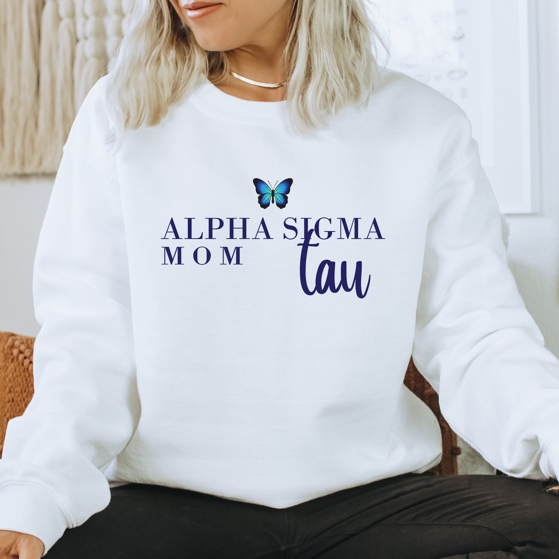 a woman sitting on a chair wearing a white sweatshirt