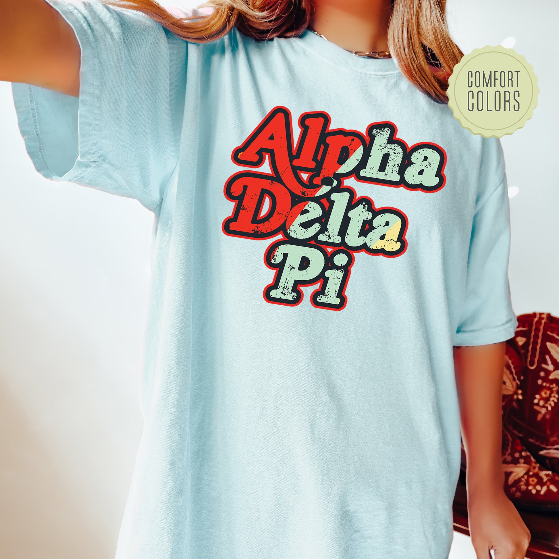 a woman wearing a light blue shirt with the words ahha delta pi on it