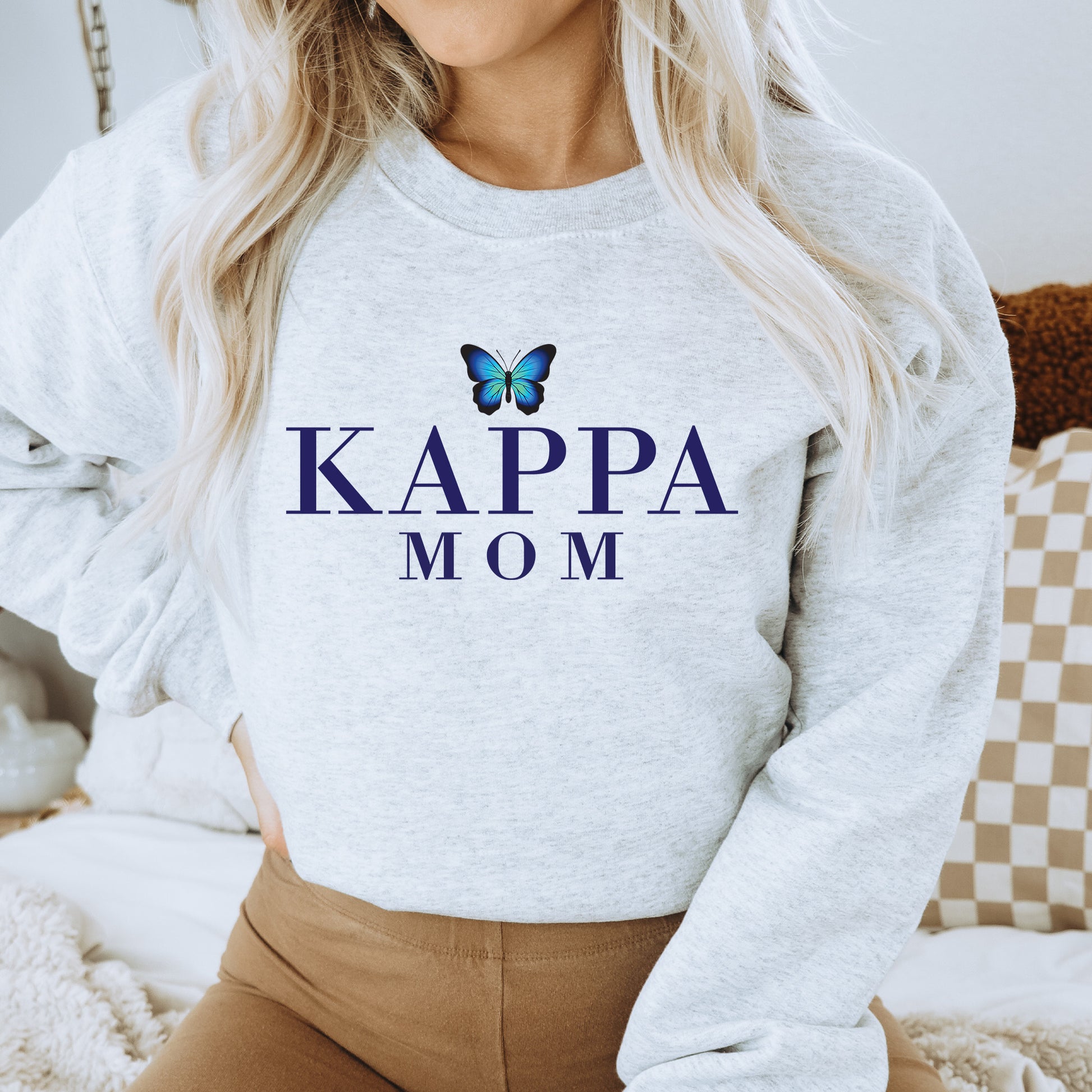 a woman wearing a sweatshirt that says kappa mom