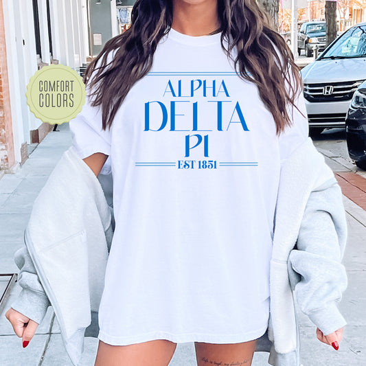 a woman wearing a white shirt with blue letters on it