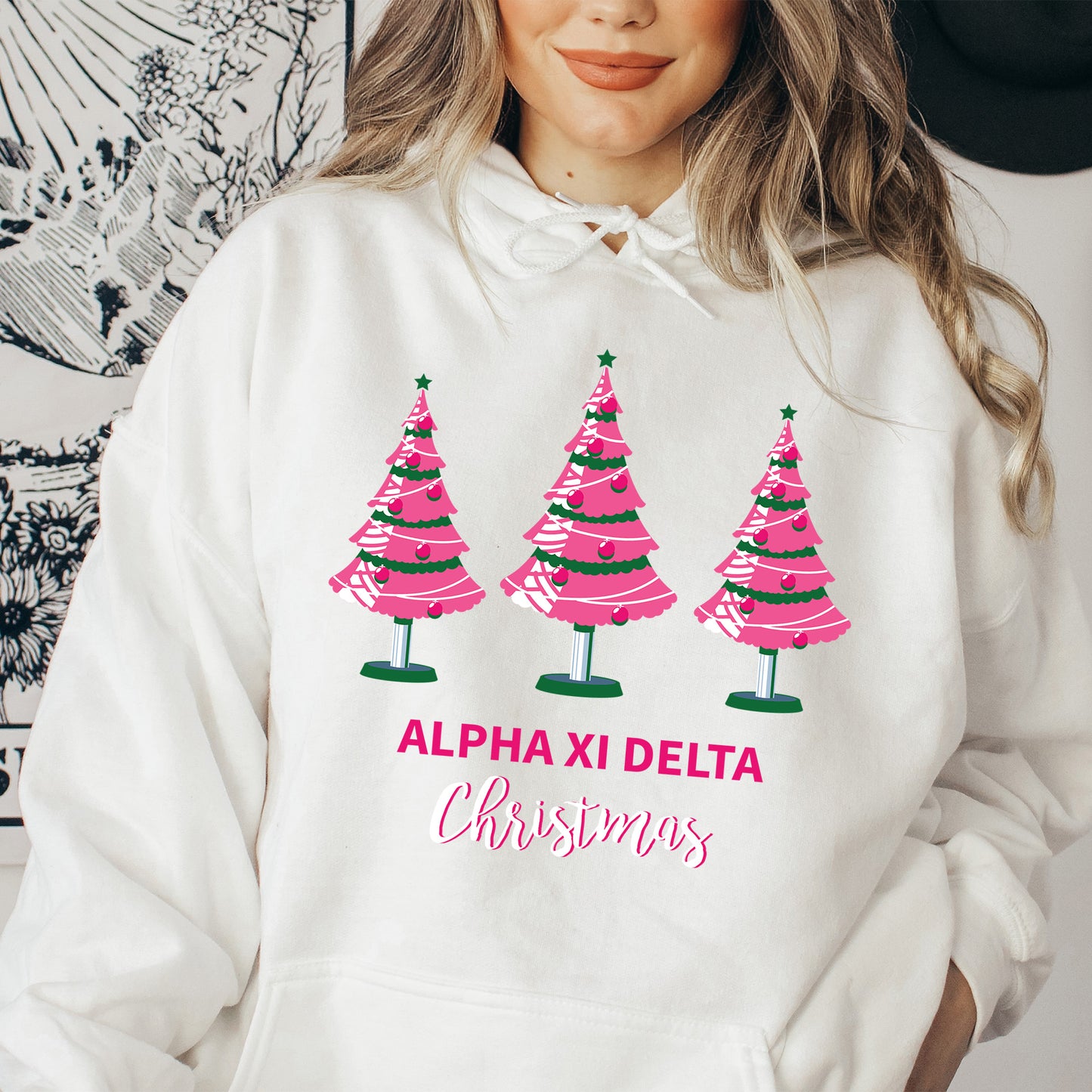 a woman wearing a white sweatshirt with pink christmas trees on it