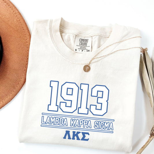 a white shirt with a blue print on it next to a brown hat
