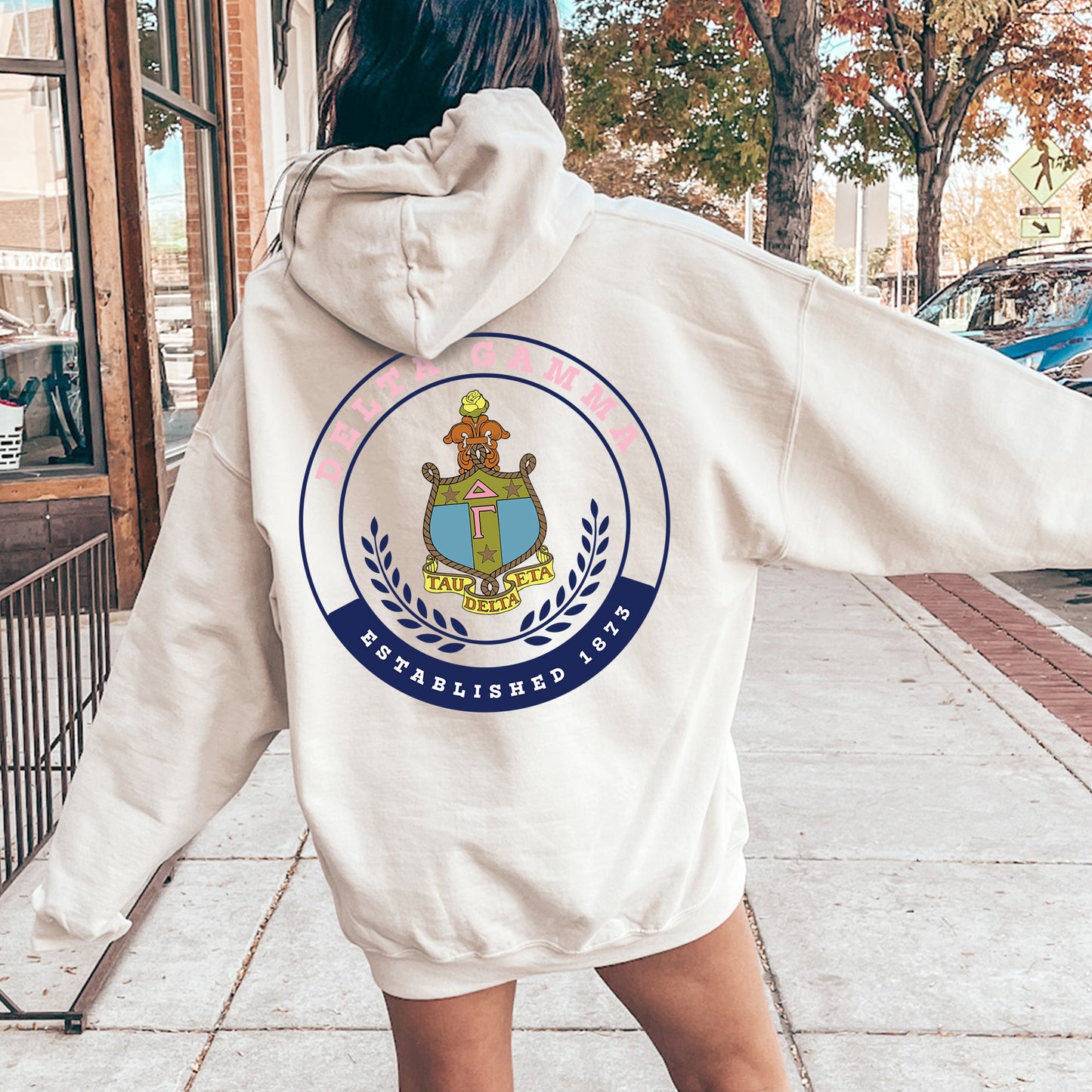 a woman in a white hoodie is walking down the street