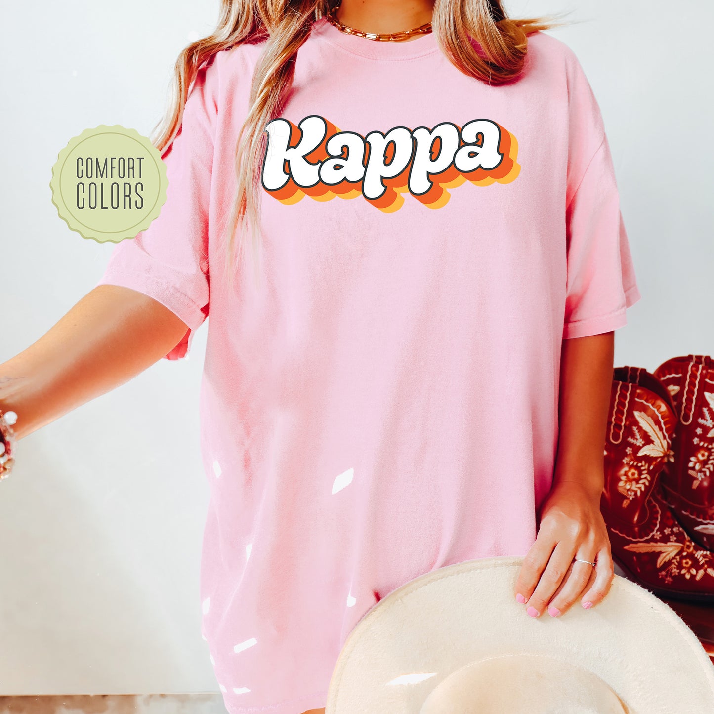 a woman wearing a pink shirt with the word kappa on it