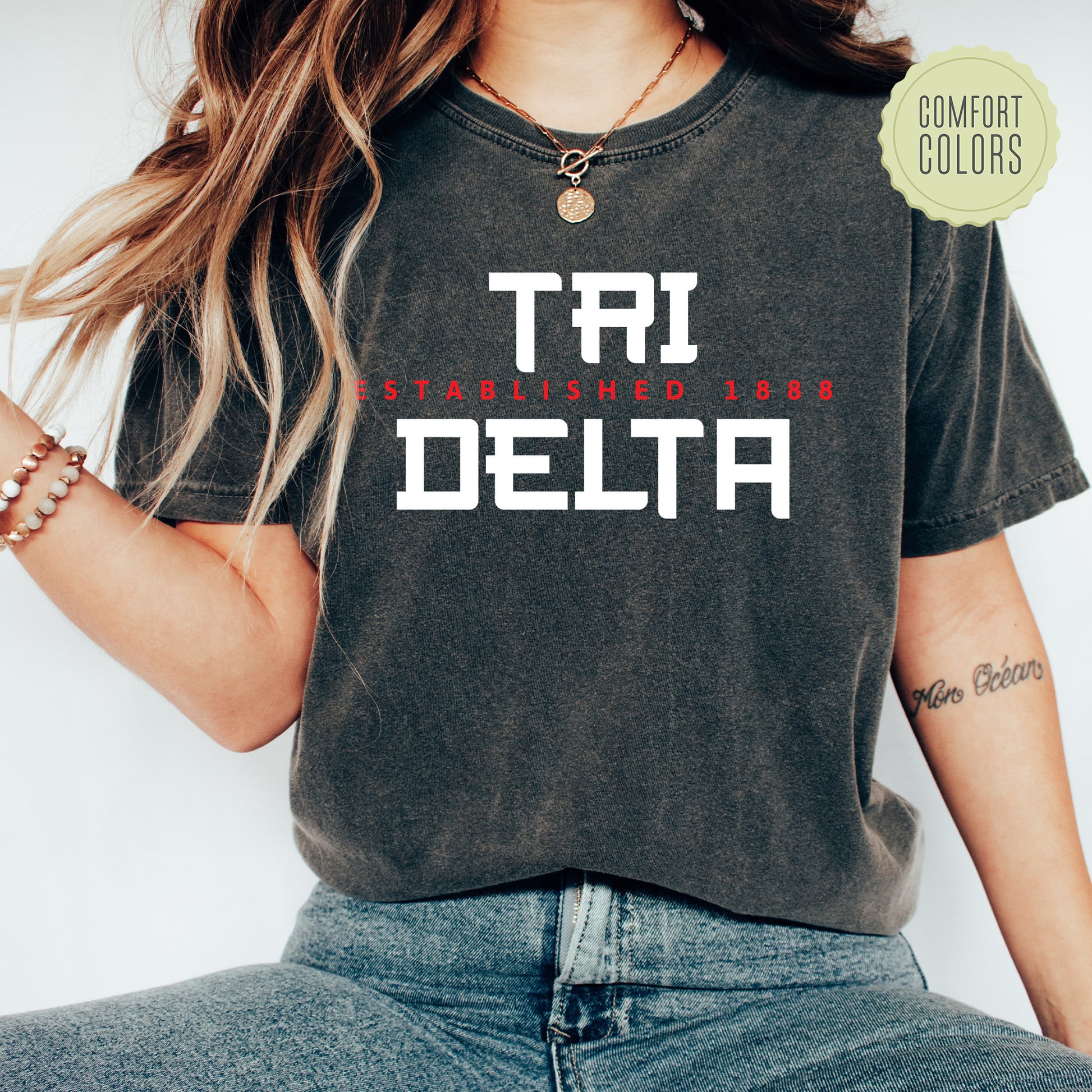 a woman wearing a t - shirt with the word tri delta printed on it