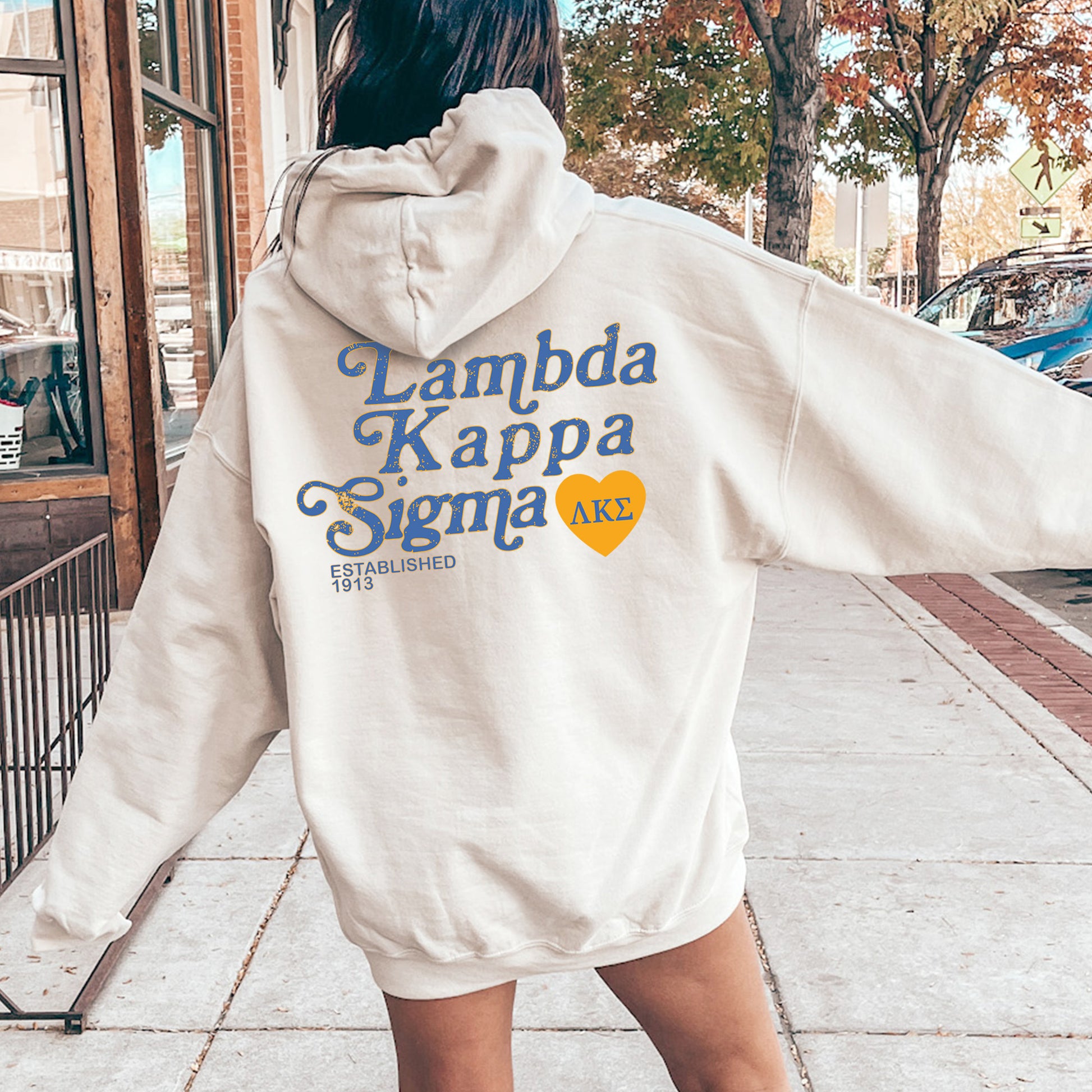 a woman in a white hoodie is walking down the street