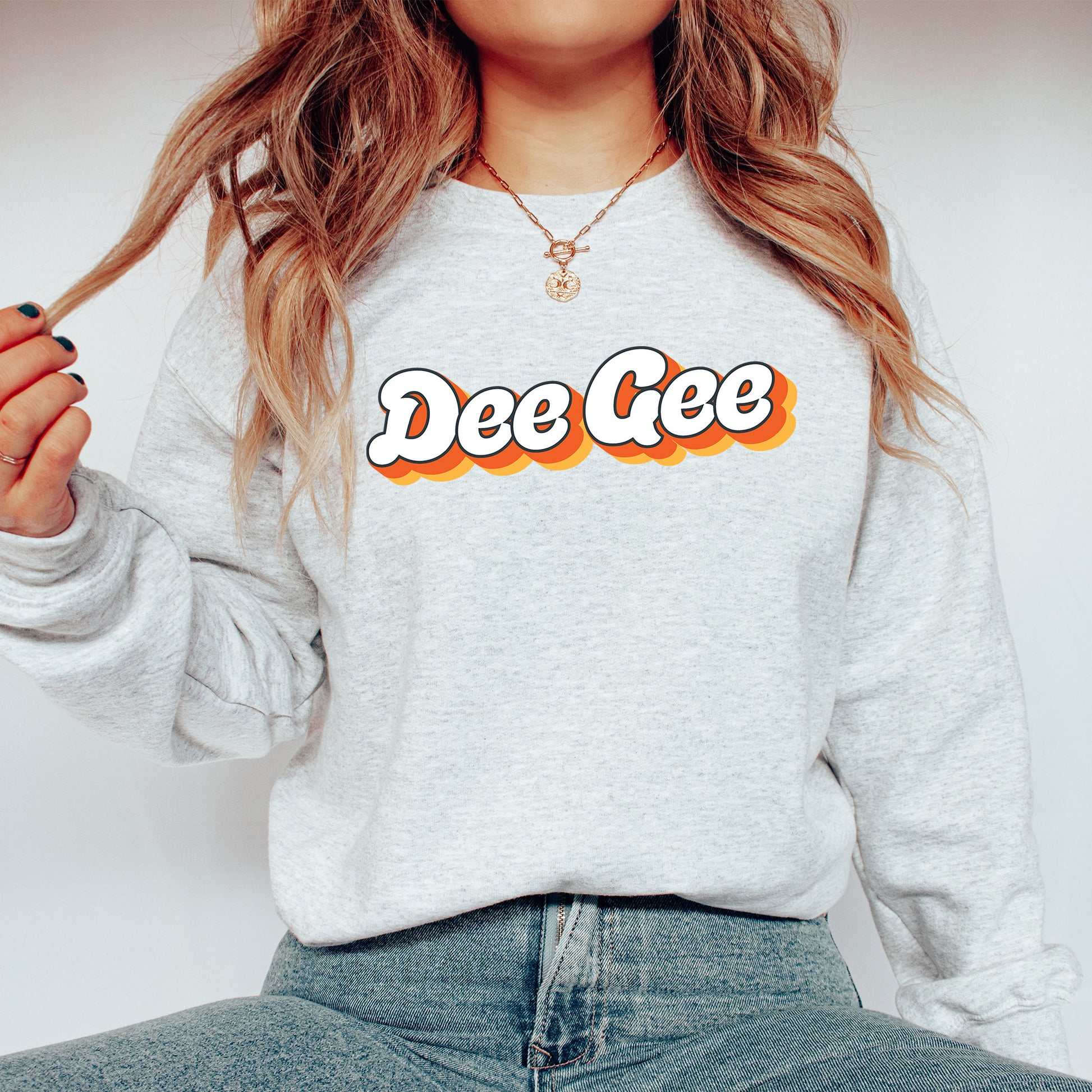 a woman wearing a sweatshirt that says dee gee