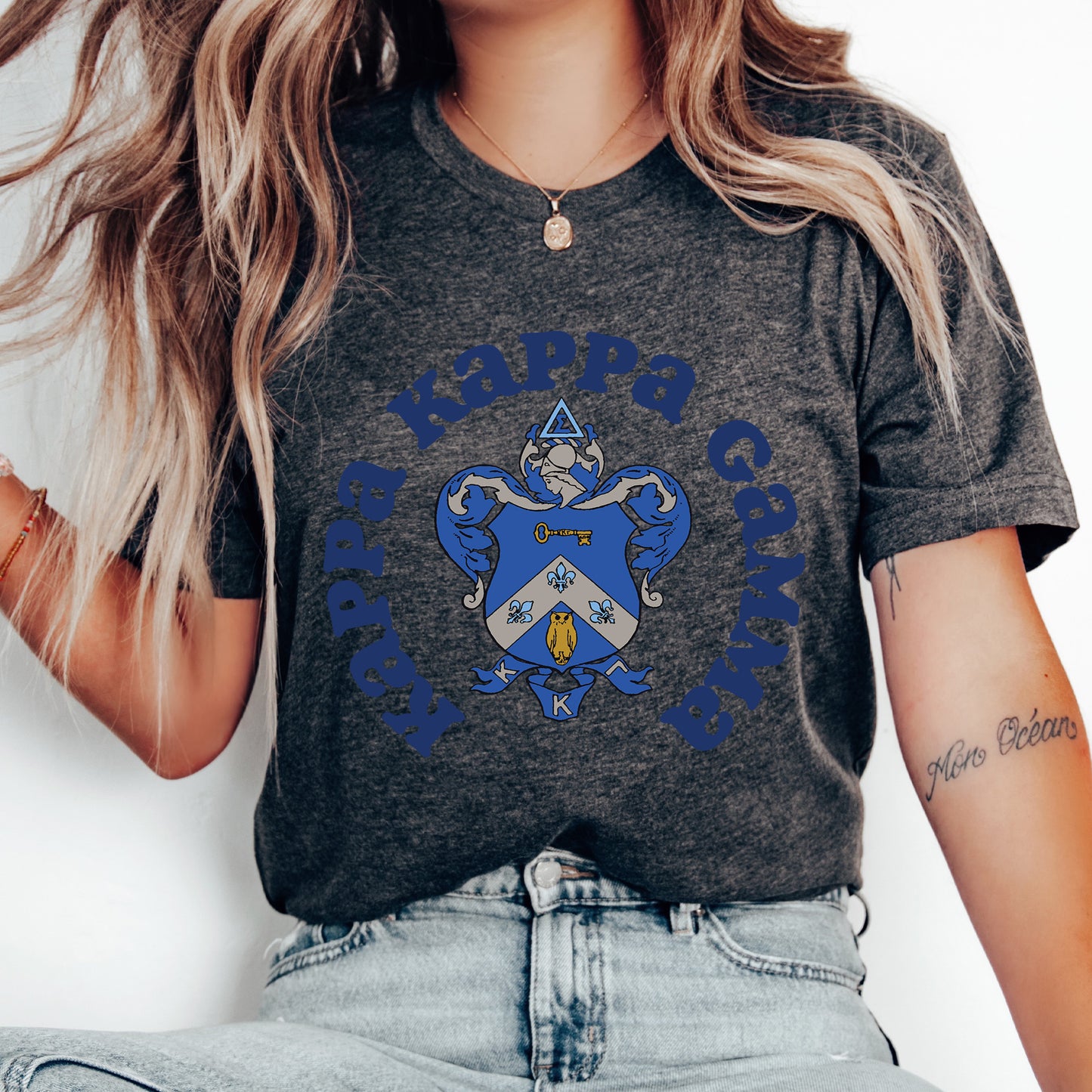 a woman wearing a gray shirt with a blue crest on it