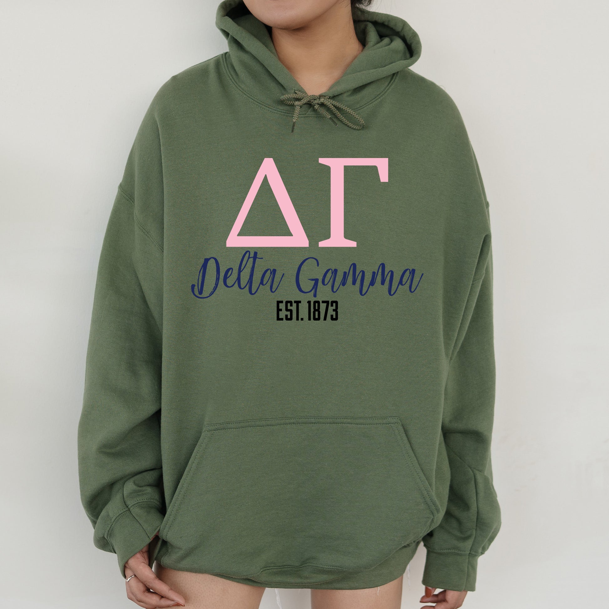 a woman wearing a green hoodie with pink letters on it