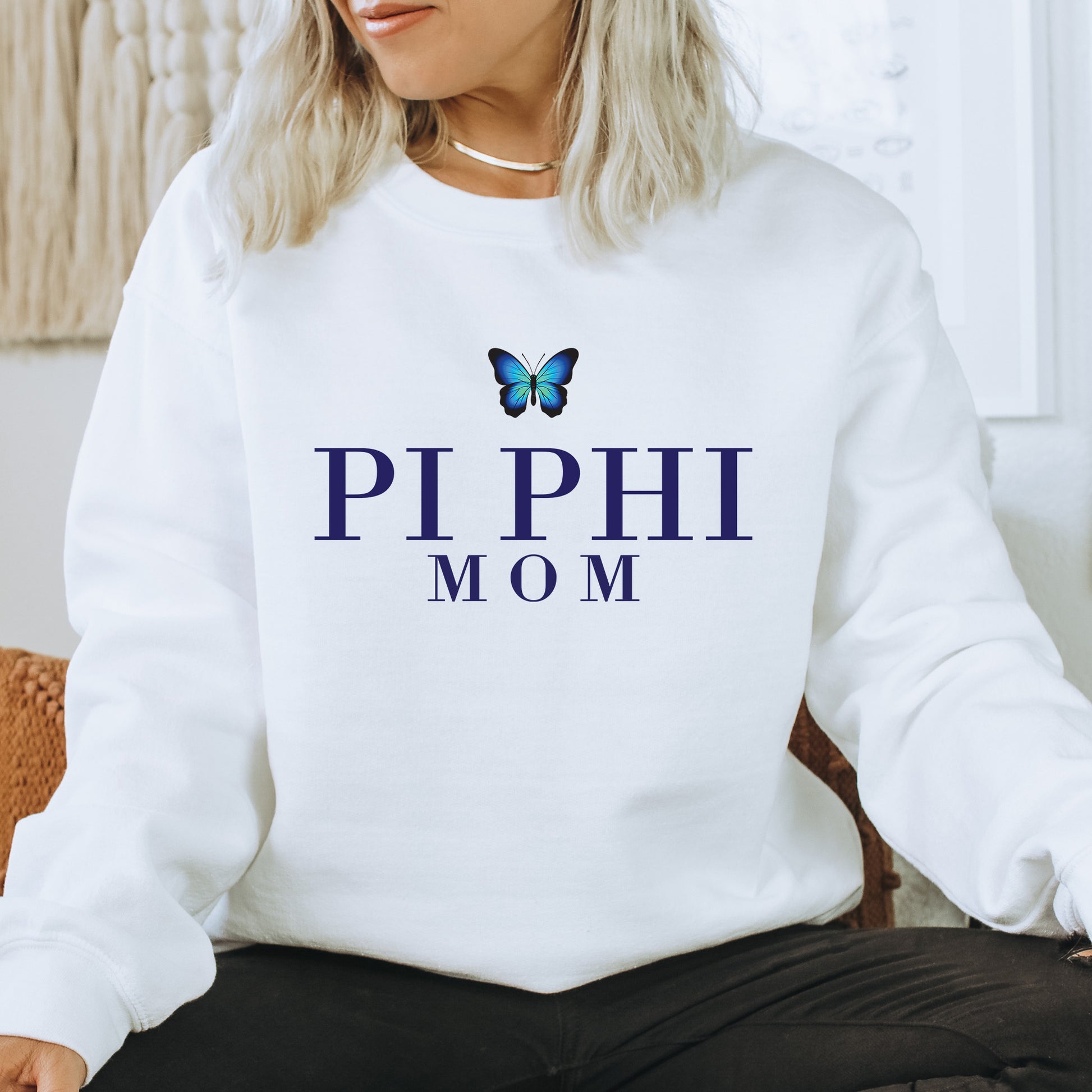 a woman sitting on a chair wearing a sweatshirt with a butterfly on it