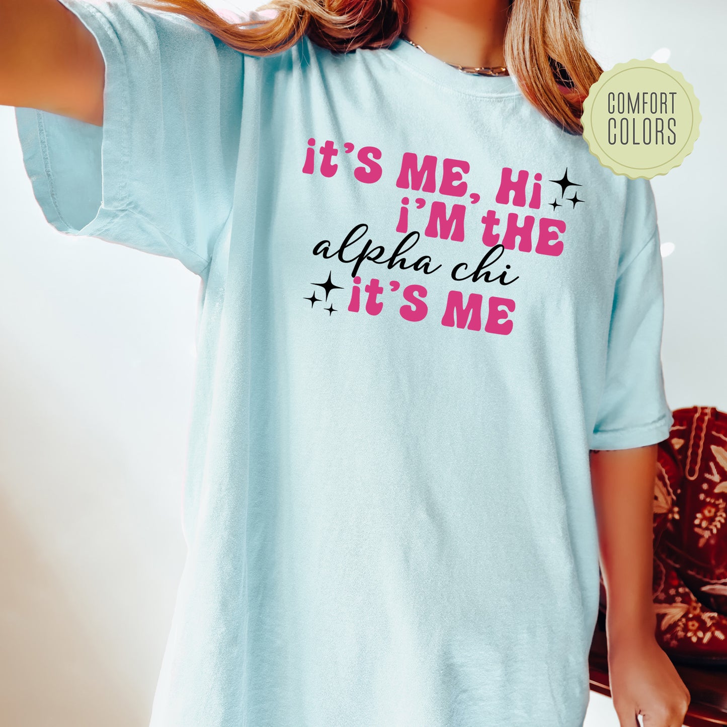 a woman wearing a blue shirt with pink writing on it