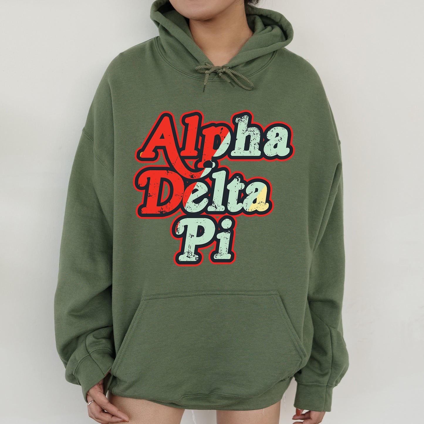 a woman wearing a green hoodie with the words aloh delta pi on it