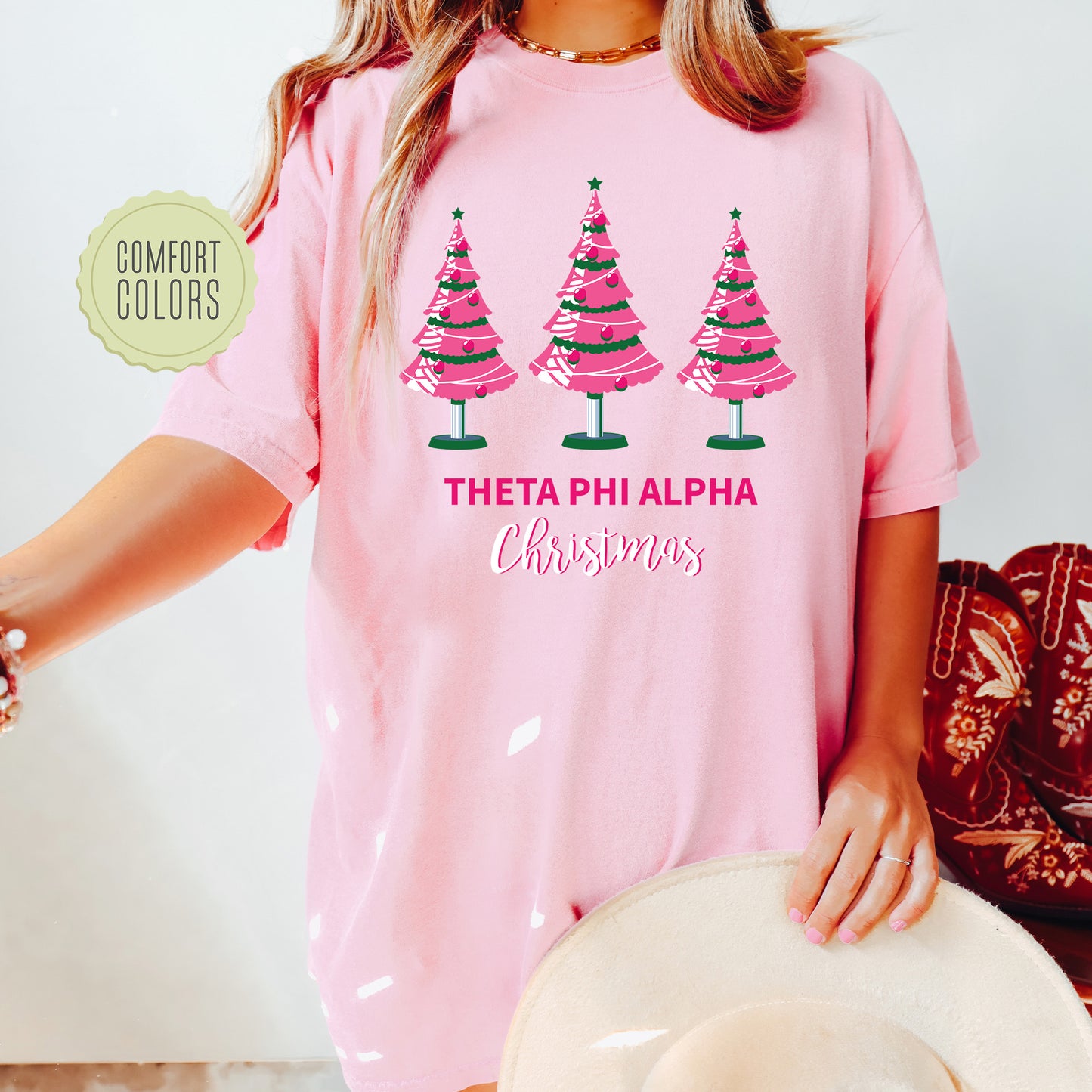 a woman wearing a pink shirt with christmas trees on it