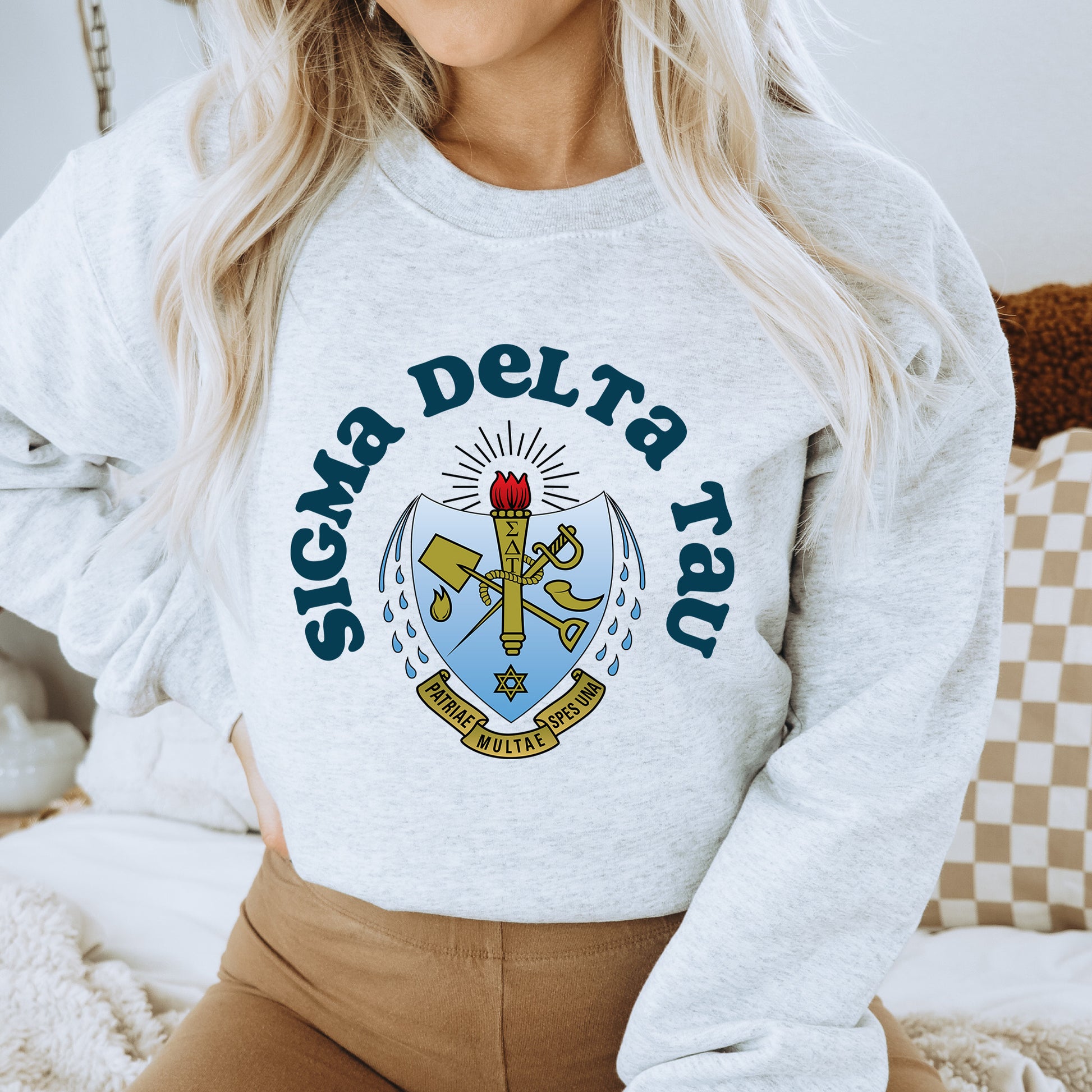 a woman wearing a sweatshirt with a coat of arms on it