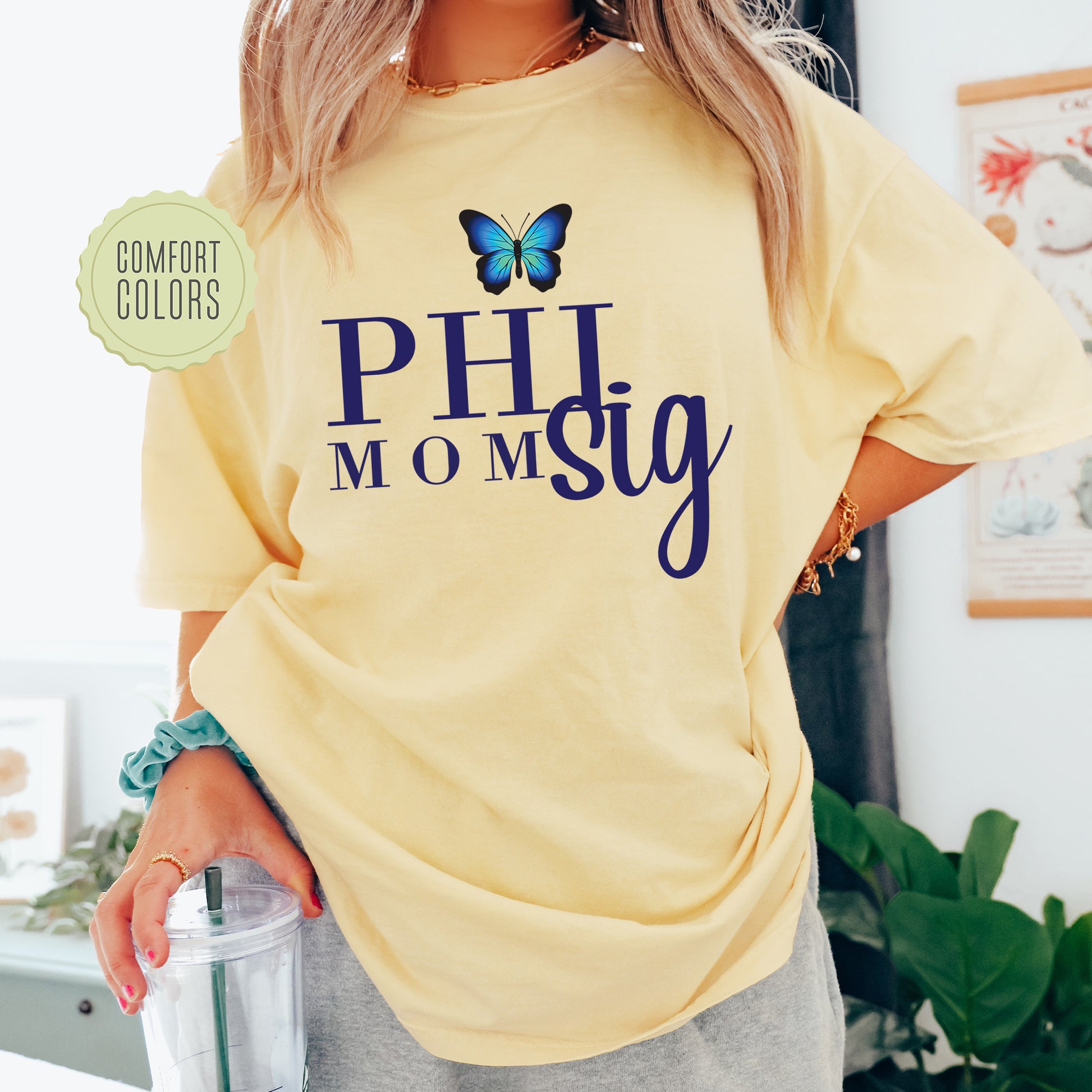 a woman wearing a yellow shirt with a butterfly on it