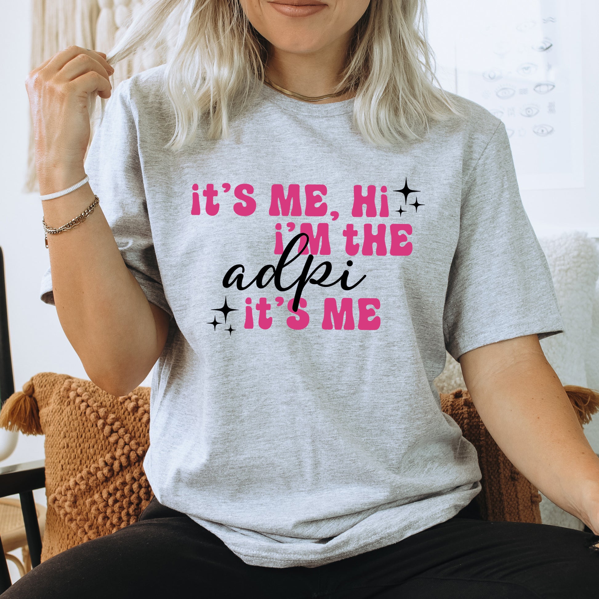 a woman sitting on a chair wearing a t - shirt that says it's