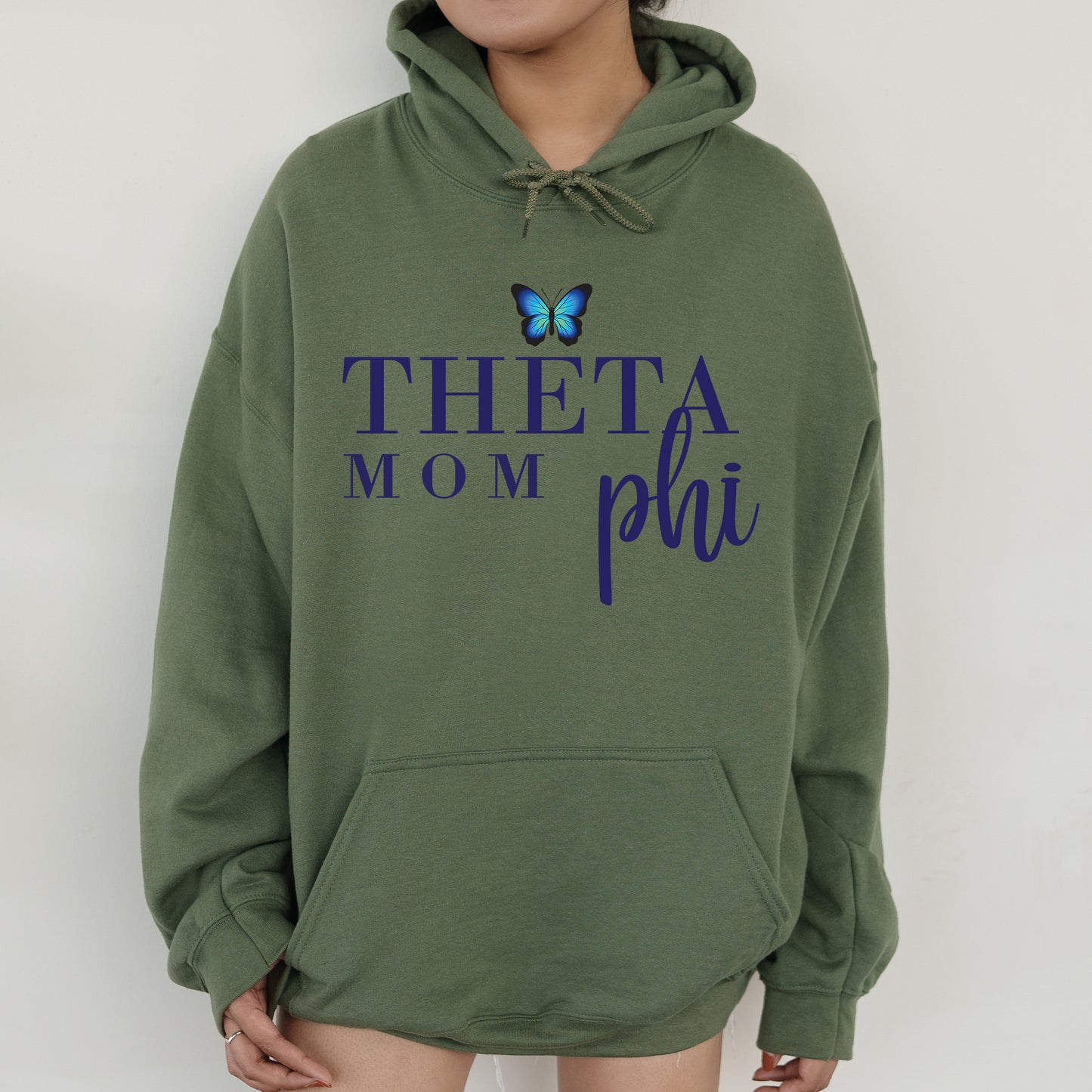 a woman wearing a sweatshirt with the words thea mom phi on it