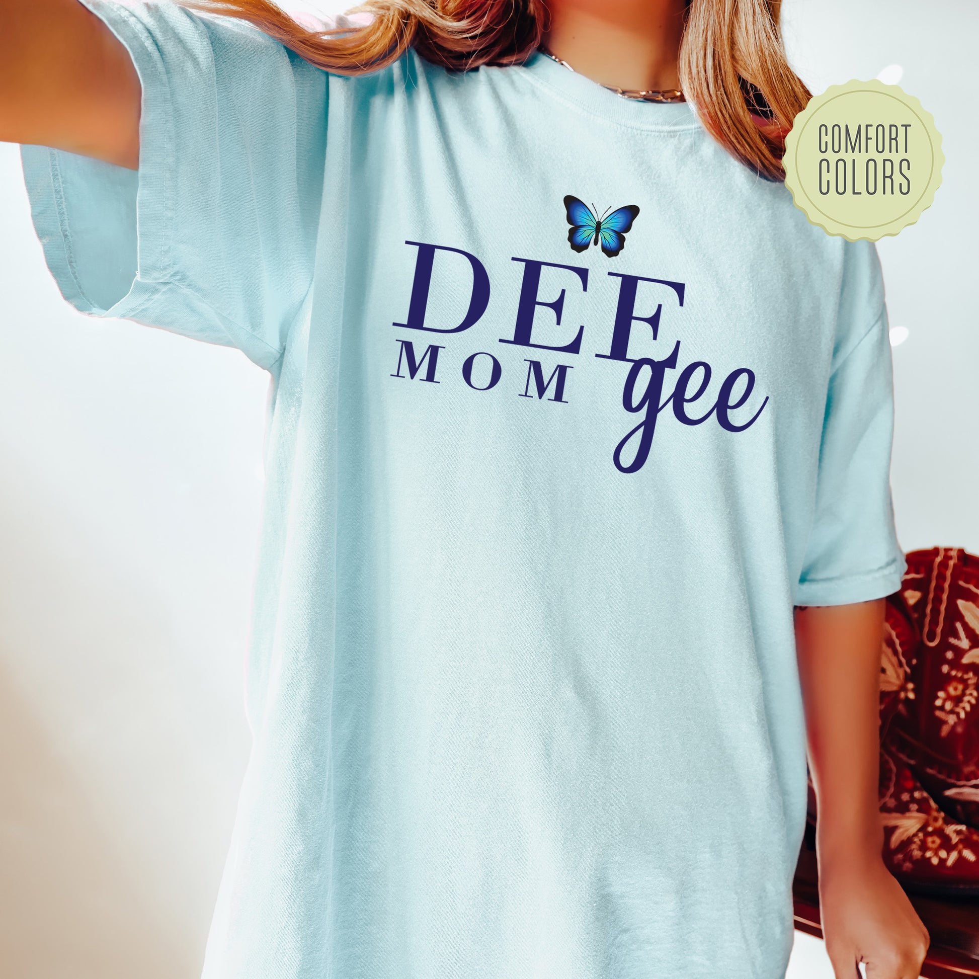 a woman wearing a blue shirt with a butterfly on it