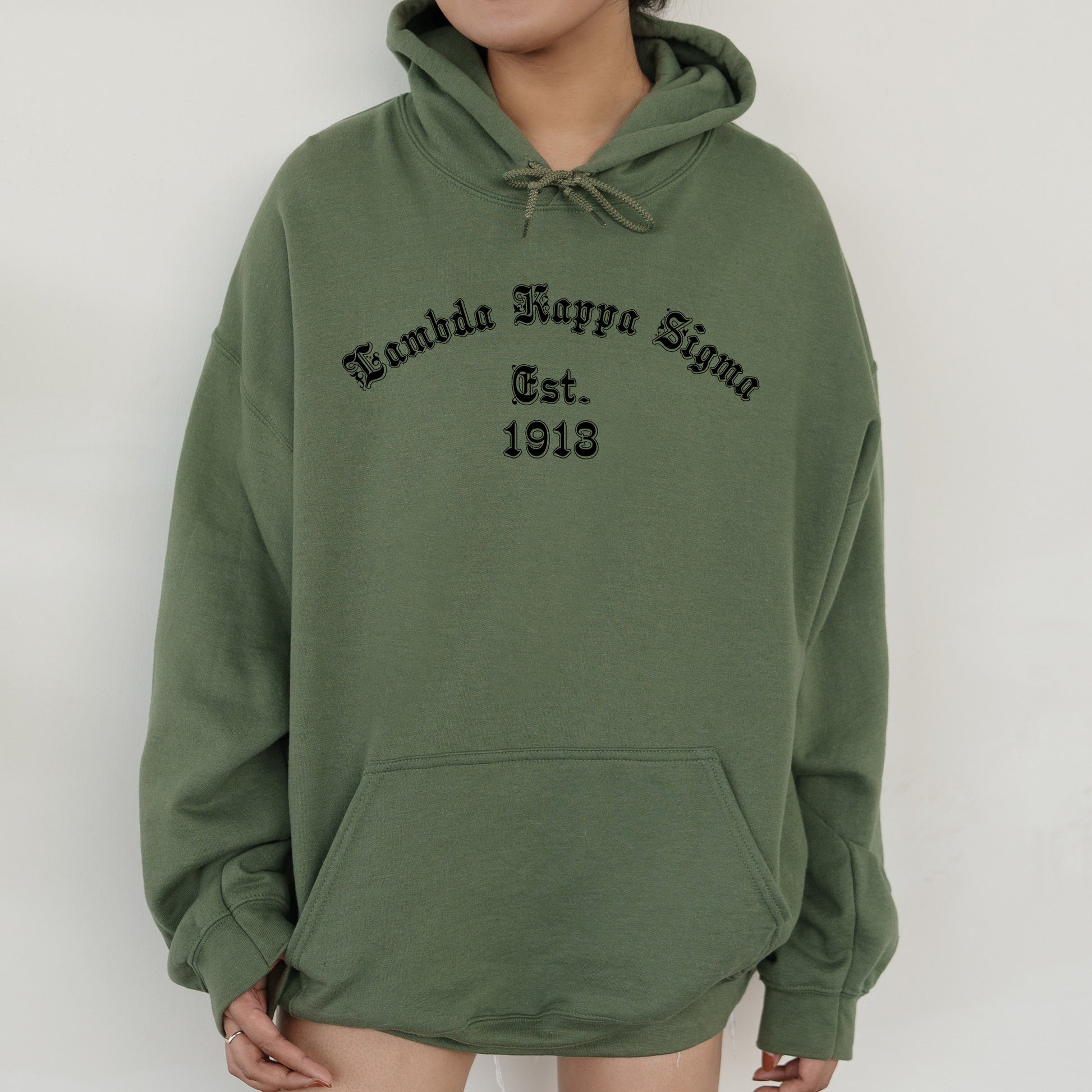 a woman wearing a green hoodie with a black print on it