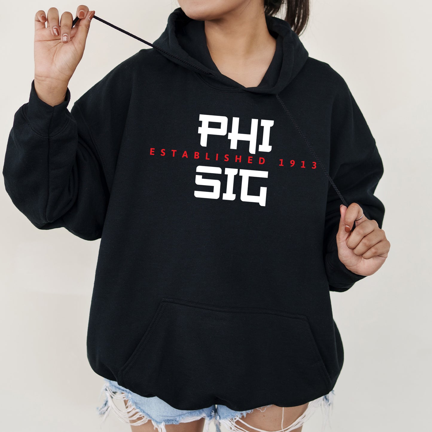 a woman in a black hoodie is holding a stick