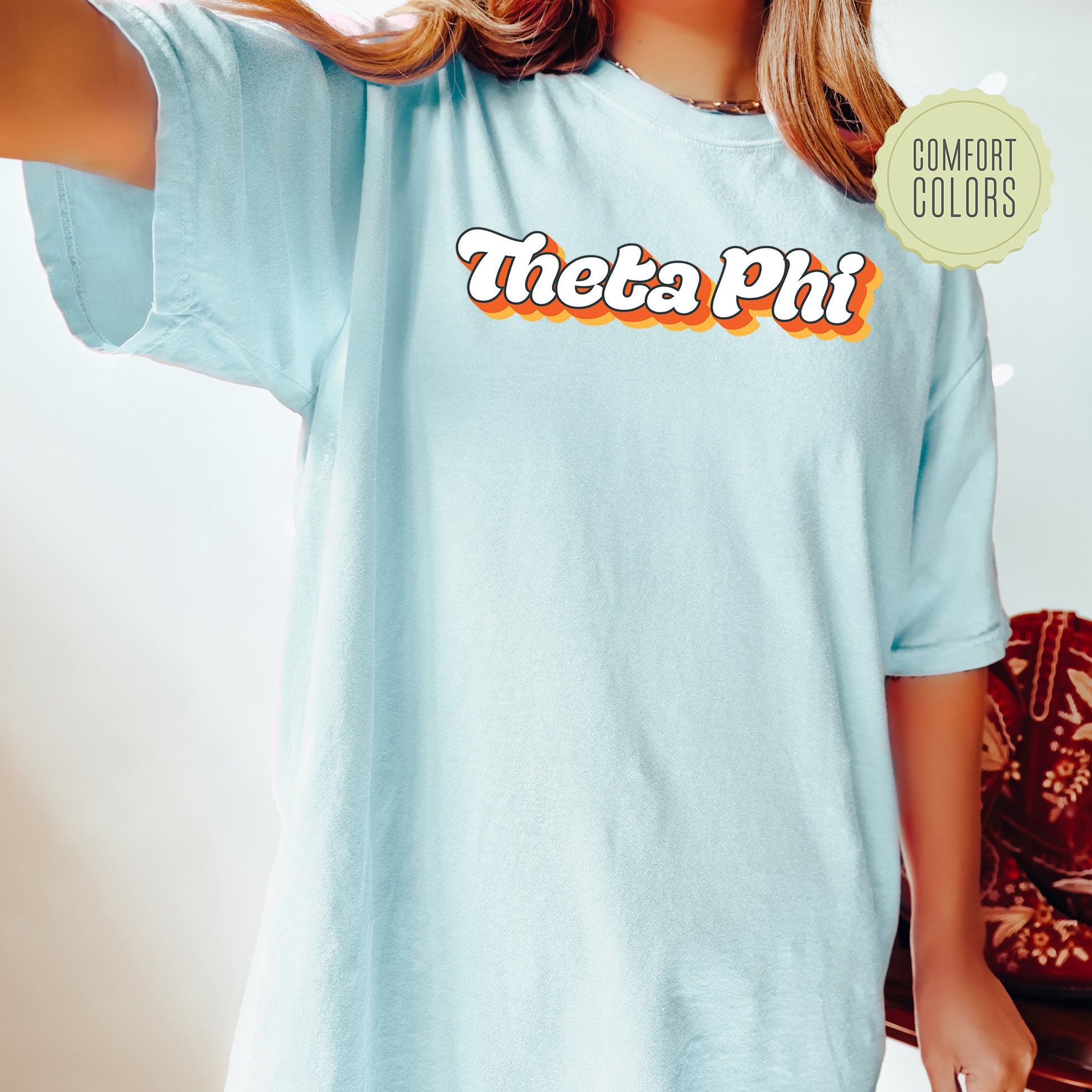 a woman wearing a blue shirt with the word thos phi on it