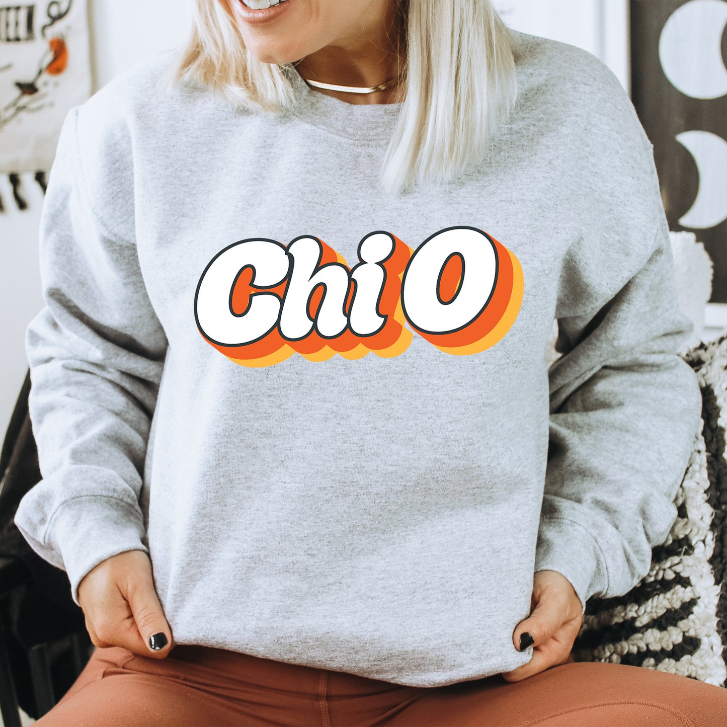 a woman wearing a grey sweatshirt with the word chio on it