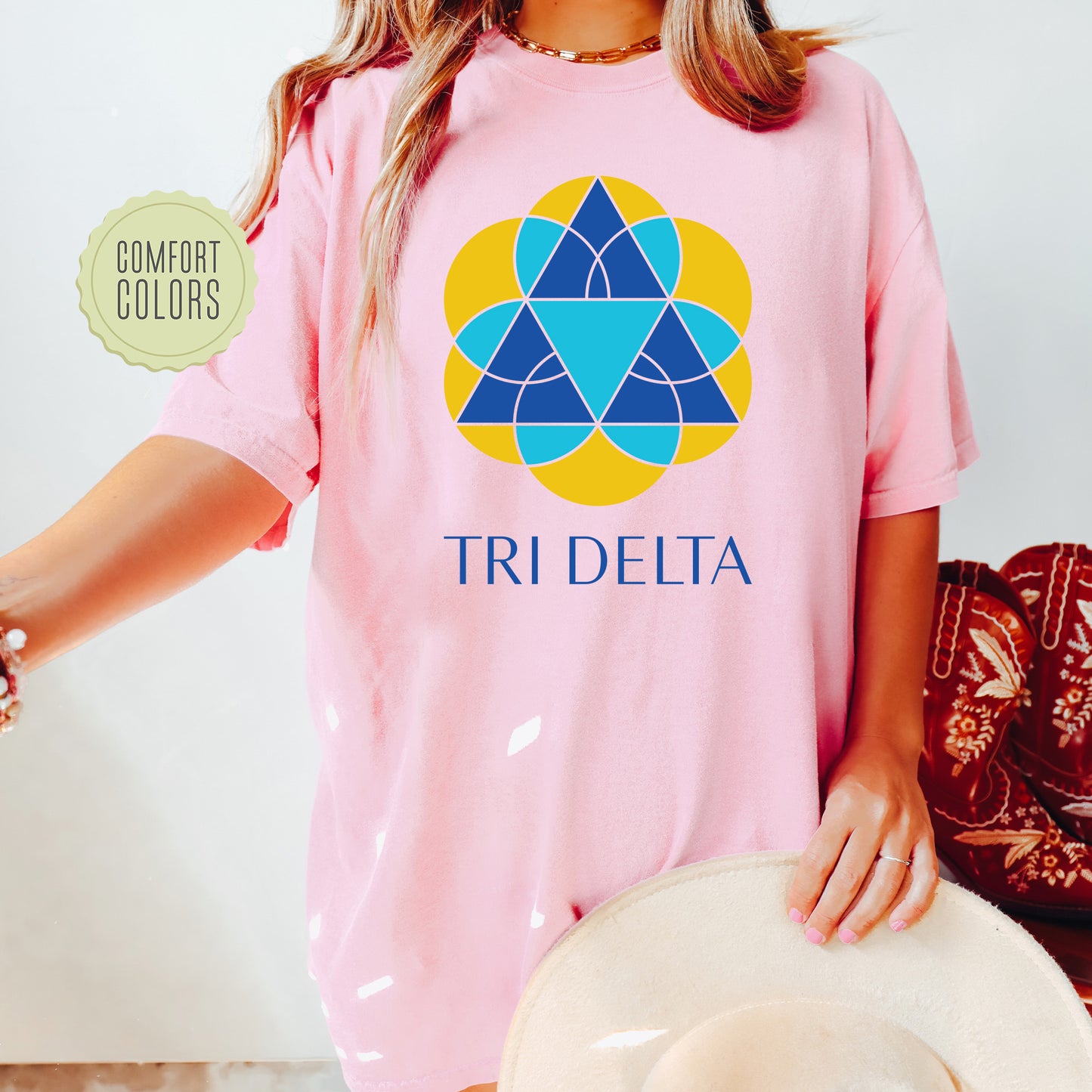 a woman wearing a pink t - shirt that says tri delta
