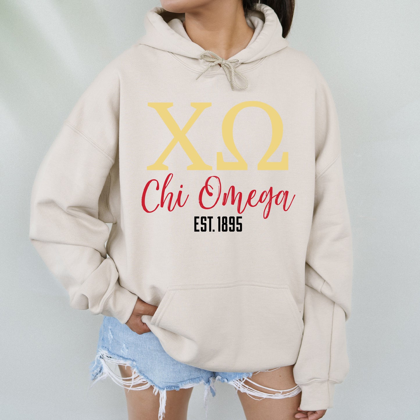 a woman wearing a sweatshirt that says xo chi omega
