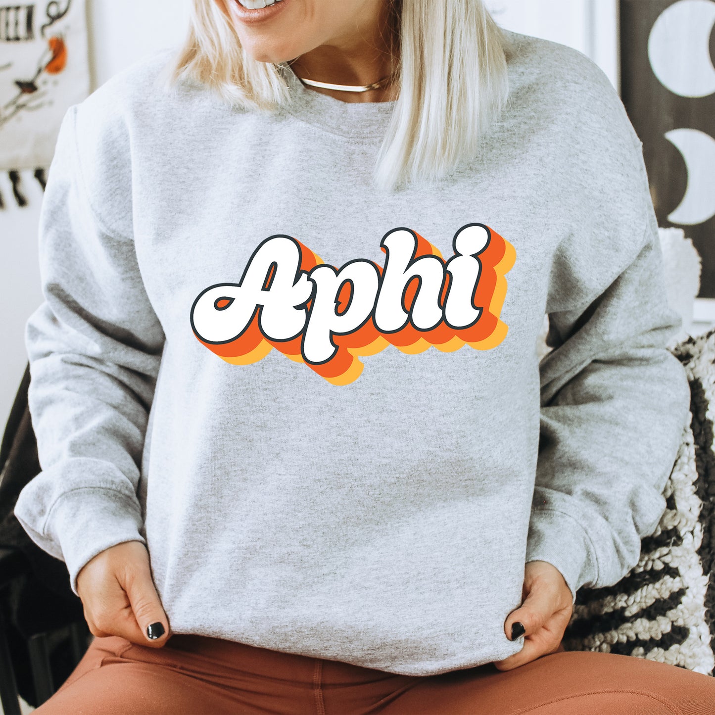 a woman wearing a sweatshirt with the word apphi on it