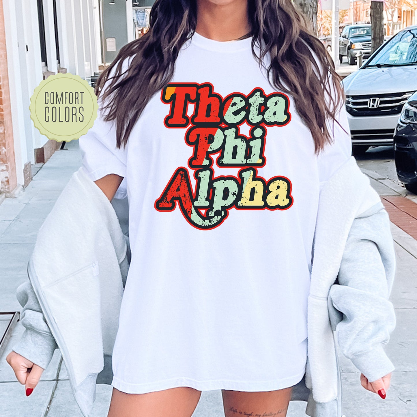a woman wearing a white shirt with the words thea phi aloha on
