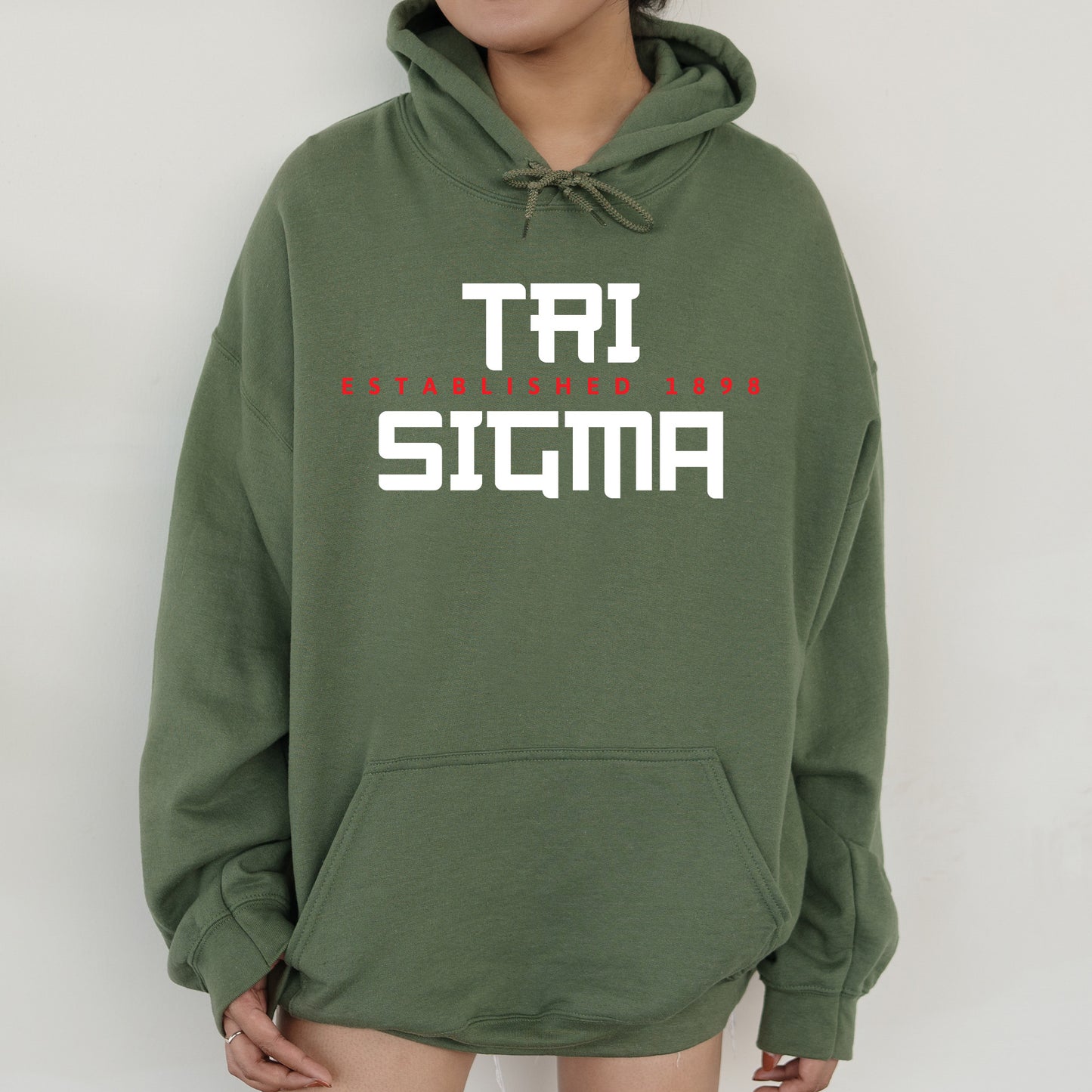a woman wearing a green sweatshirt with the words taj stigma printed on it