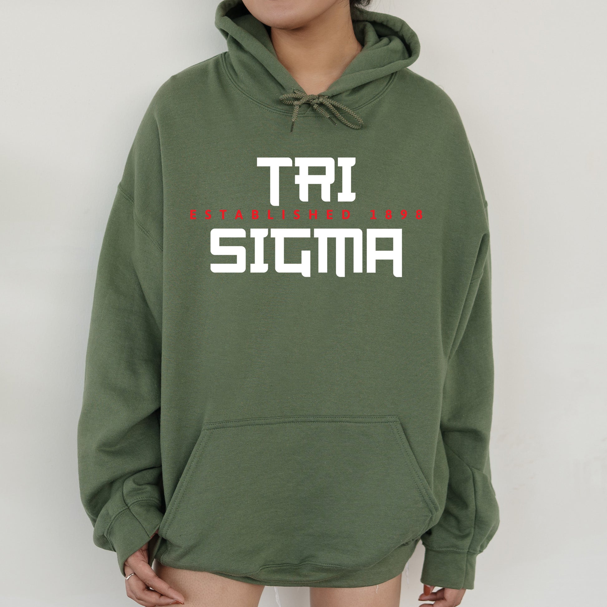 a woman wearing a green sweatshirt with the words taj stigma printed on it