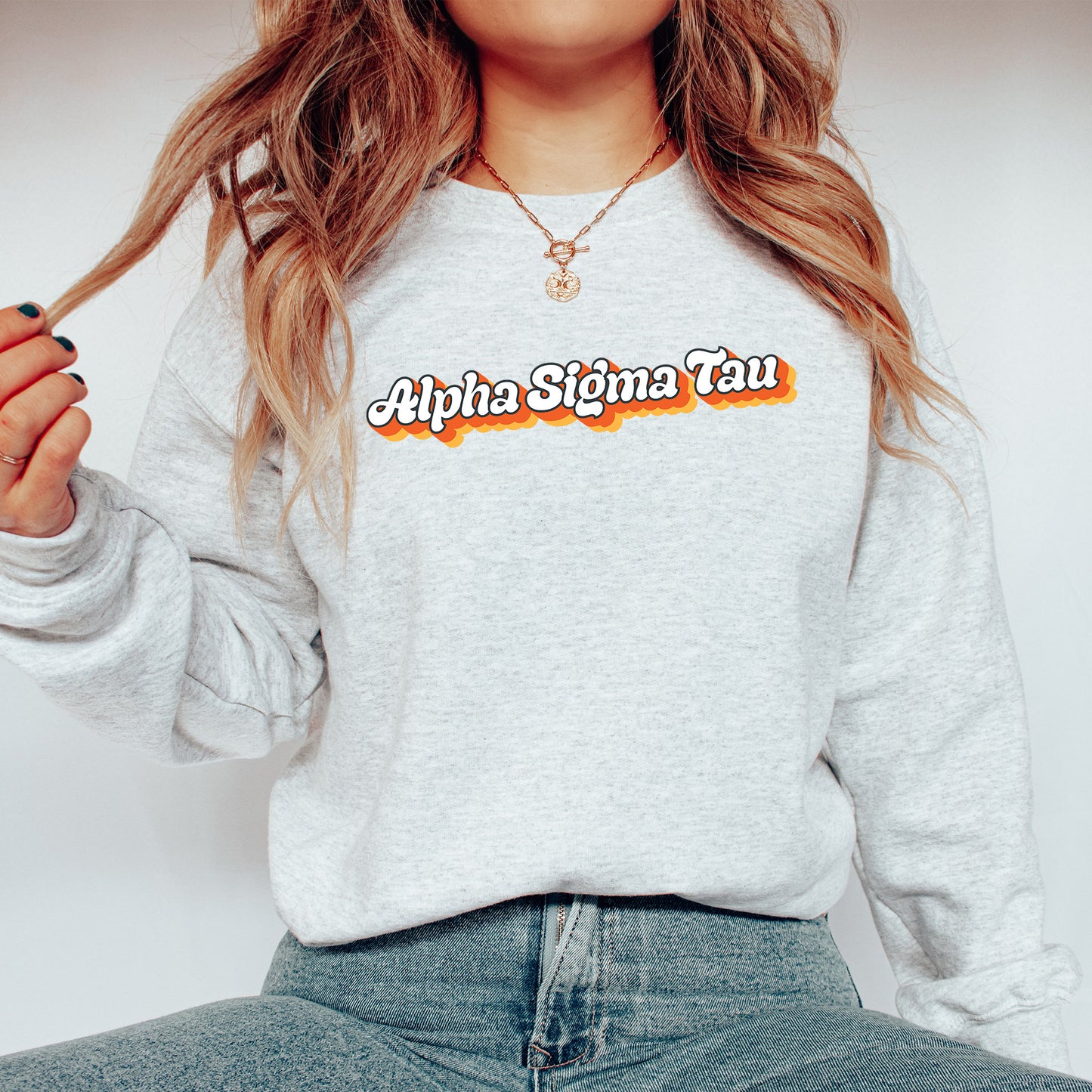 a woman with long hair wearing a sweatshirt and jeans