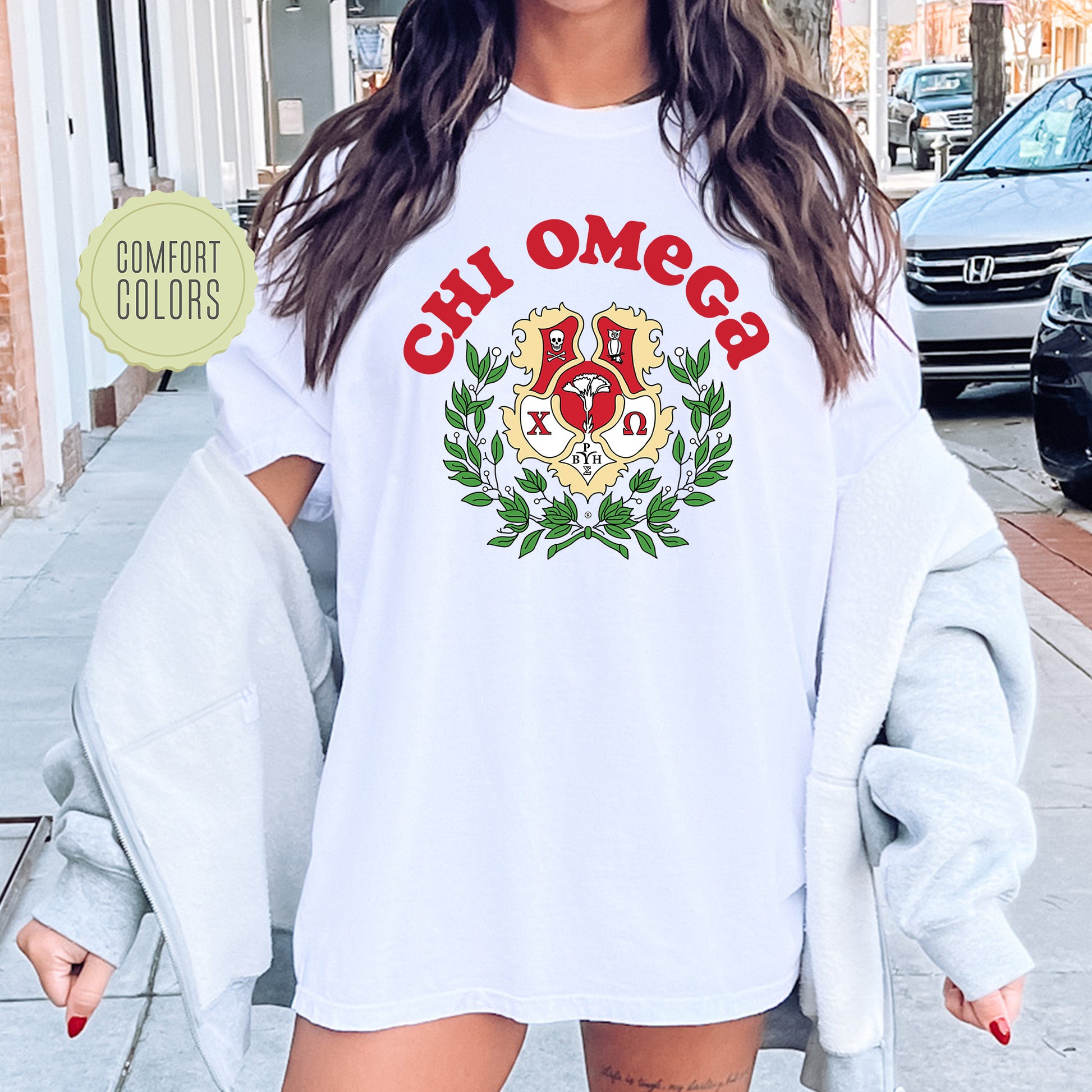 a woman wearing a white shirt with the words chi omegs on it