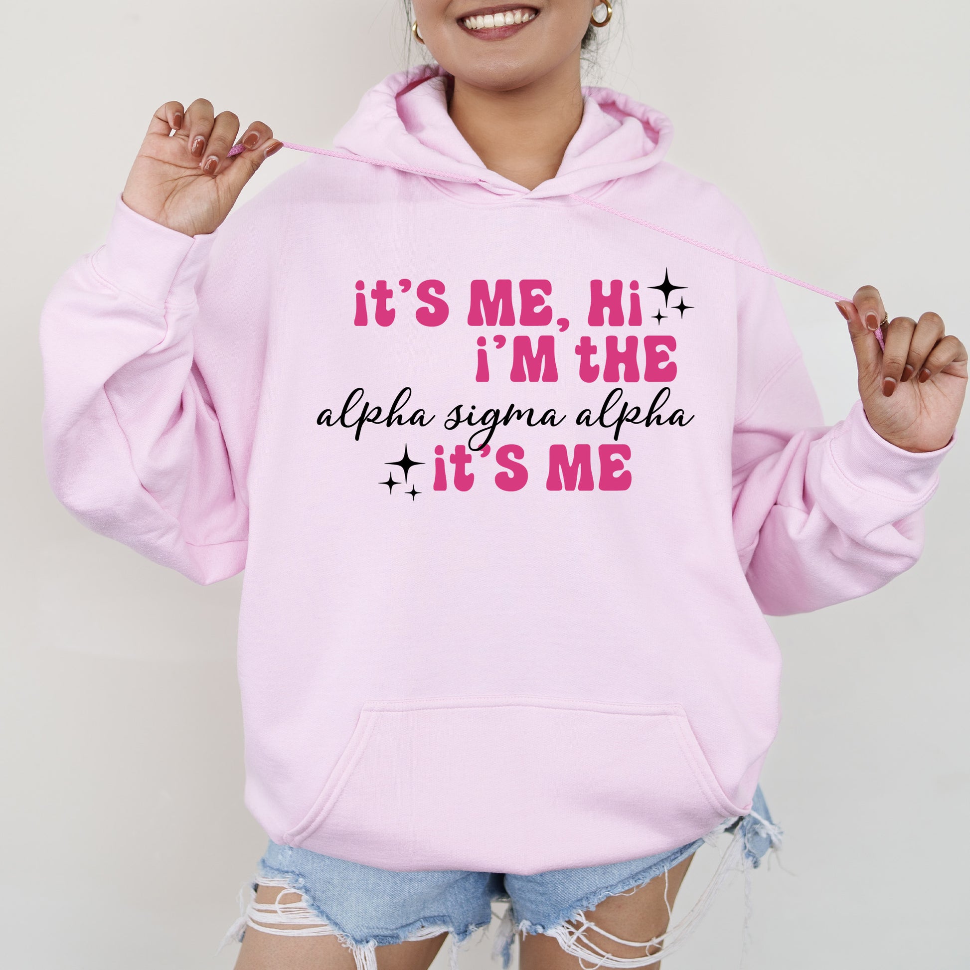 a woman wearing a pink hoodie that says it's me, i '