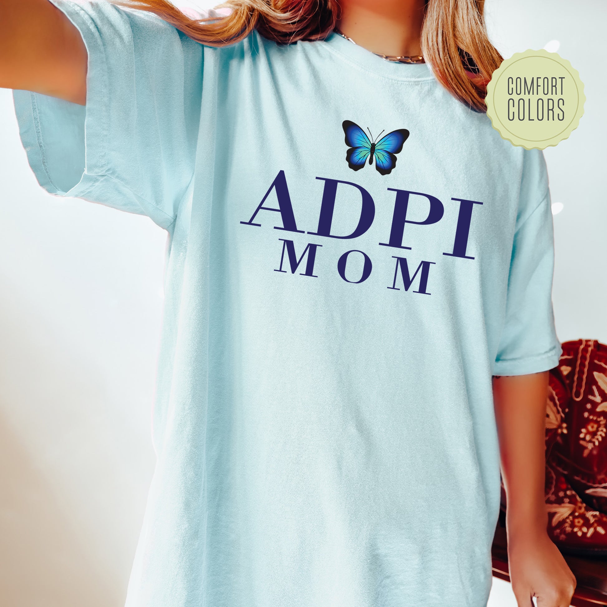 a woman wearing a blue shirt with a butterfly on it
