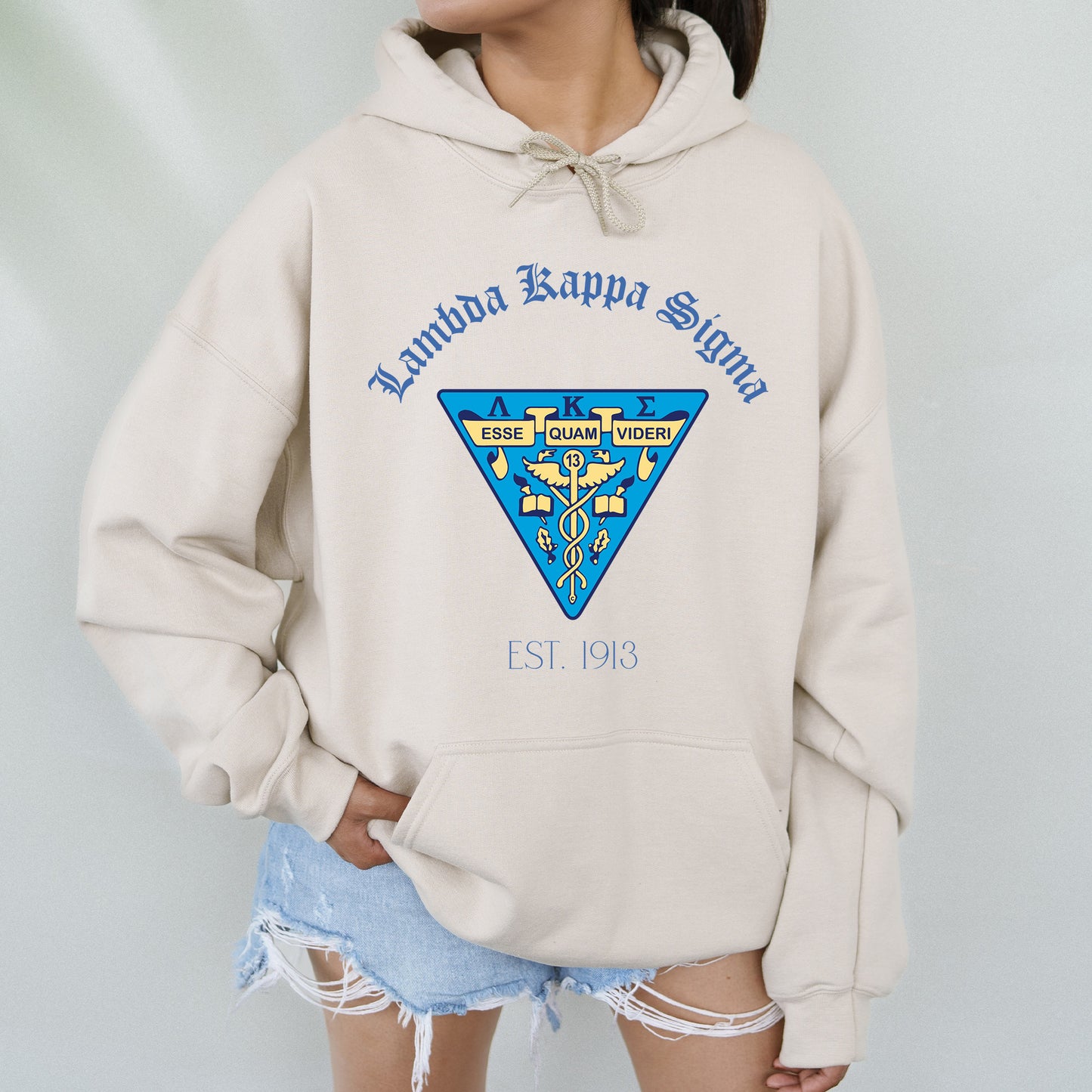 a woman wearing a white hoodie with a blue and yellow emblem