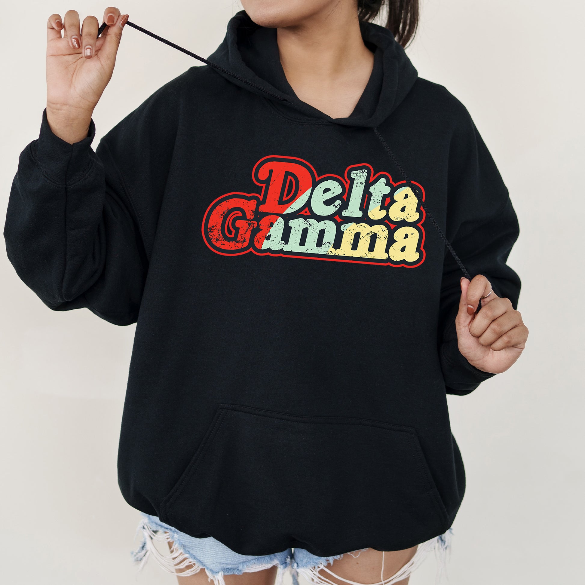 a woman wearing a black hoodie with the words delta gumma on it