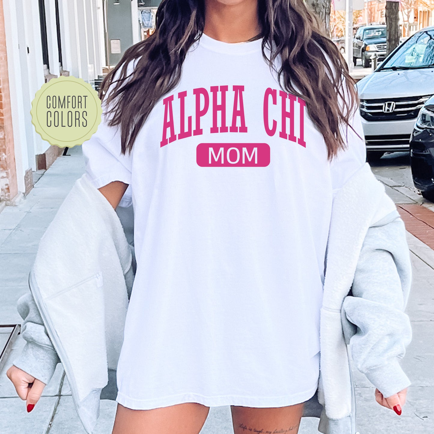 a woman wearing a white shirt with pink letters on it