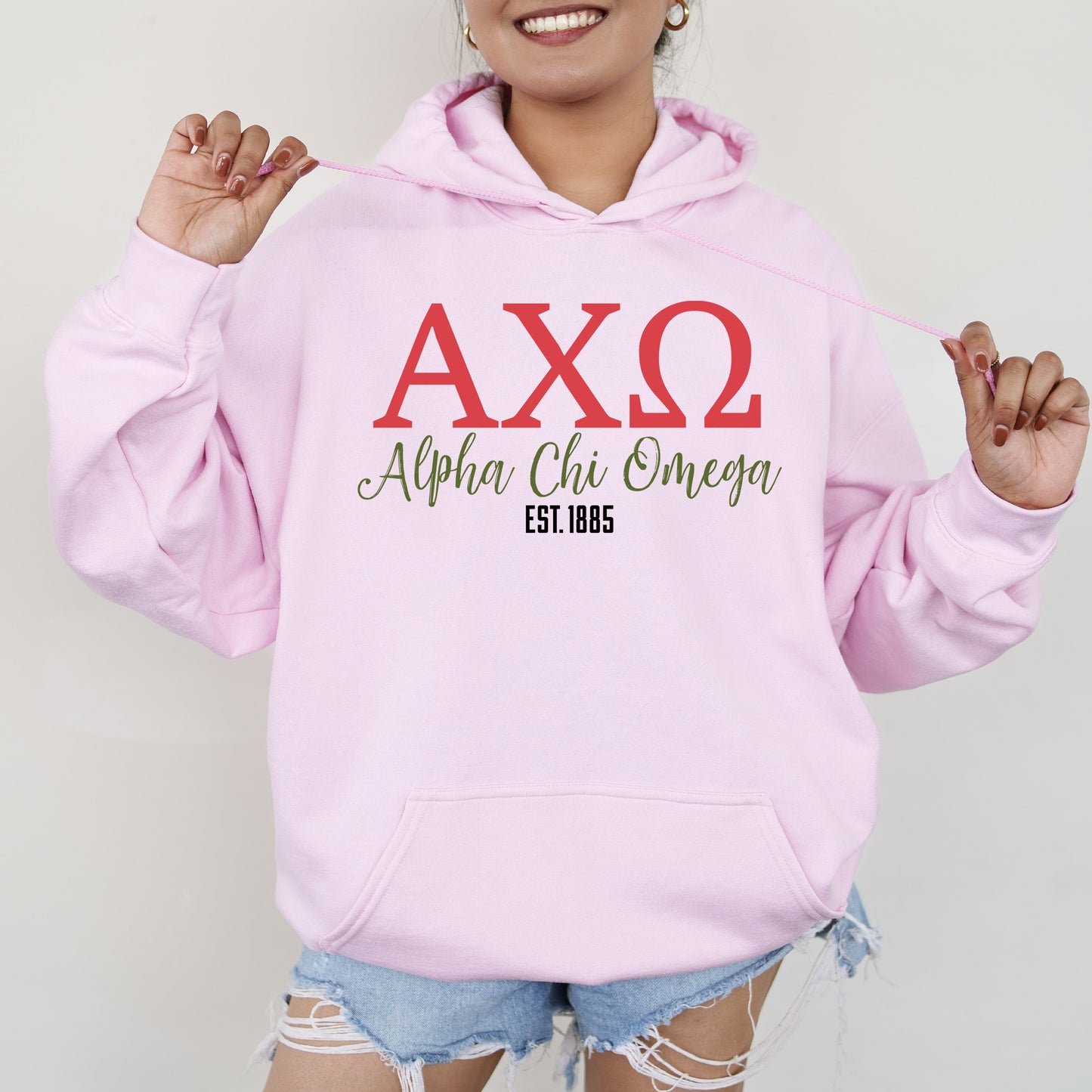 a woman wearing a pink hoodie with the word axq on it