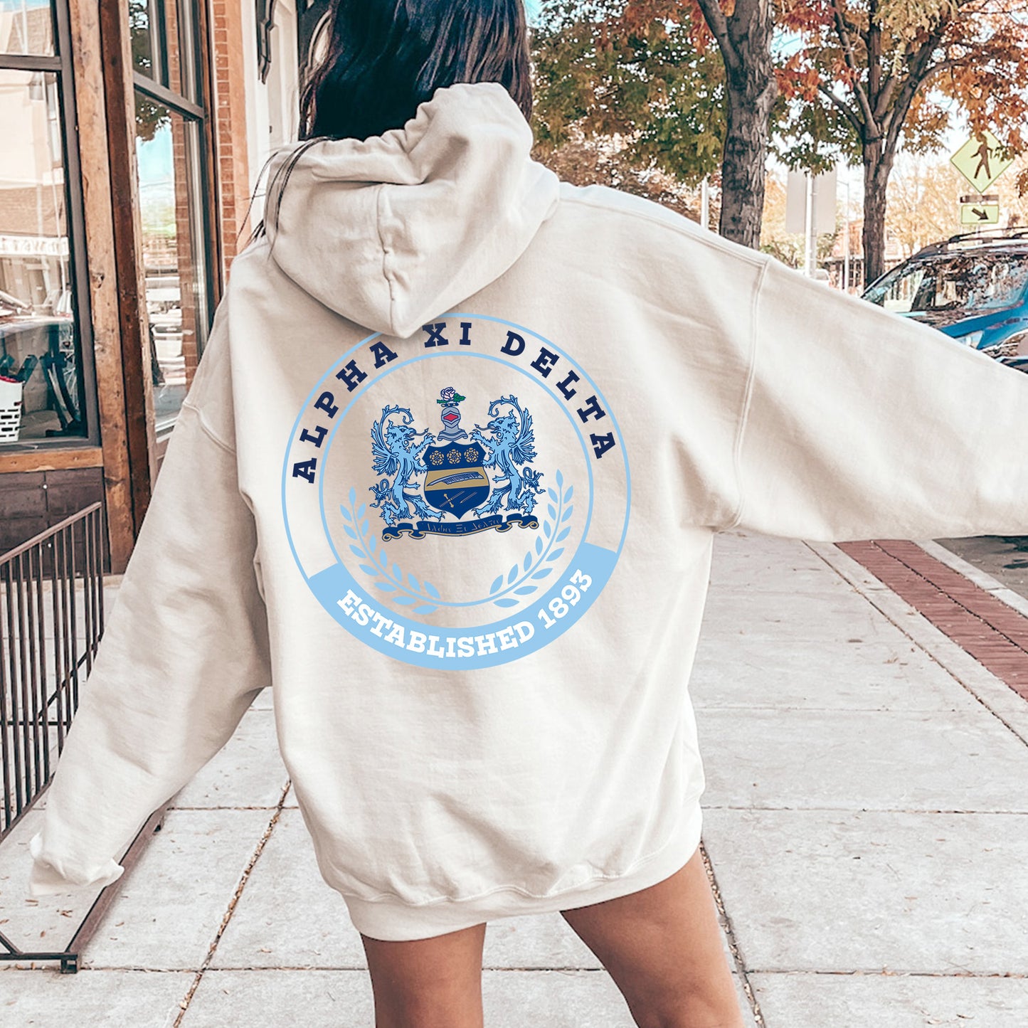 a woman walking down a sidewalk with a white jacket on