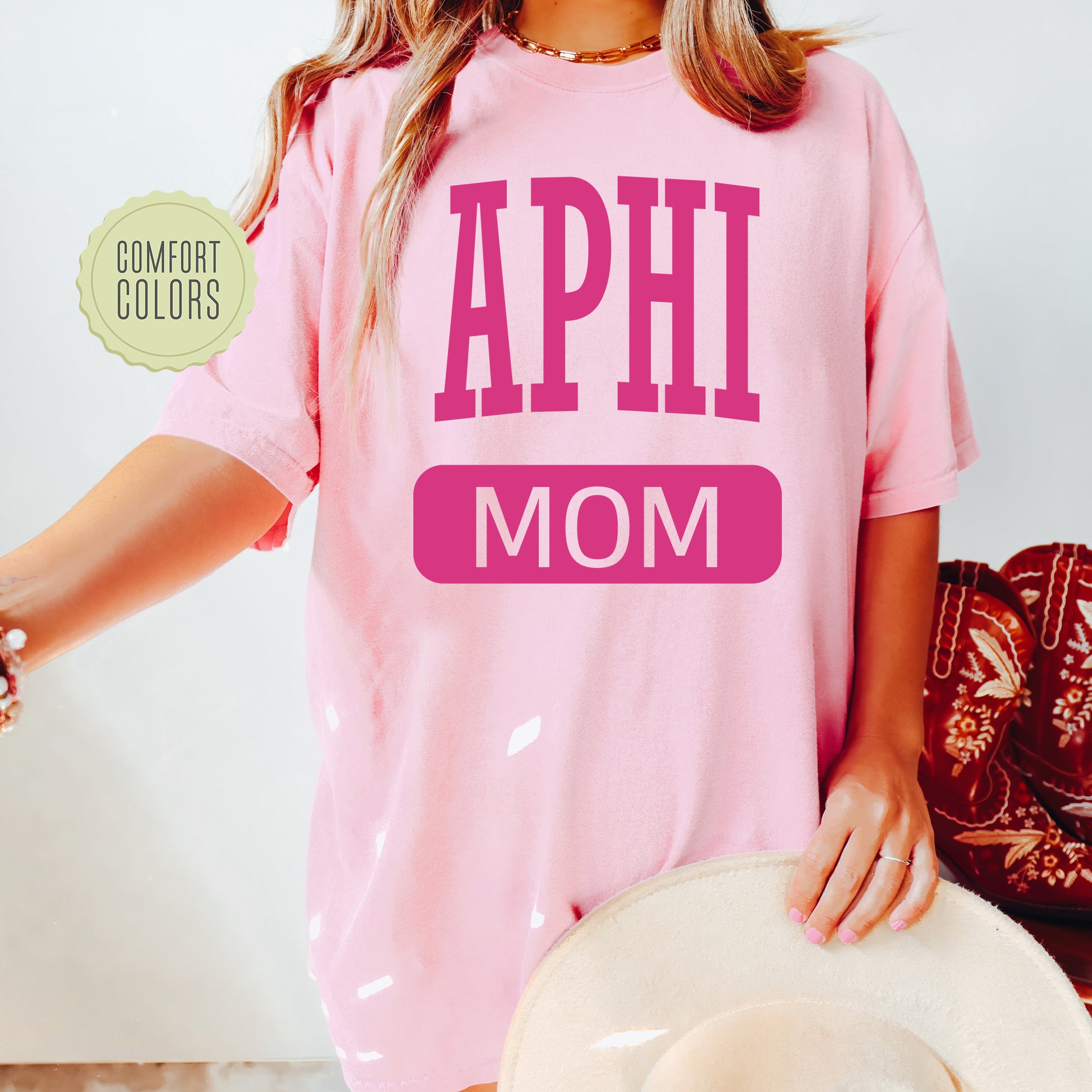 a woman wearing a pink shirt that says aphi mom