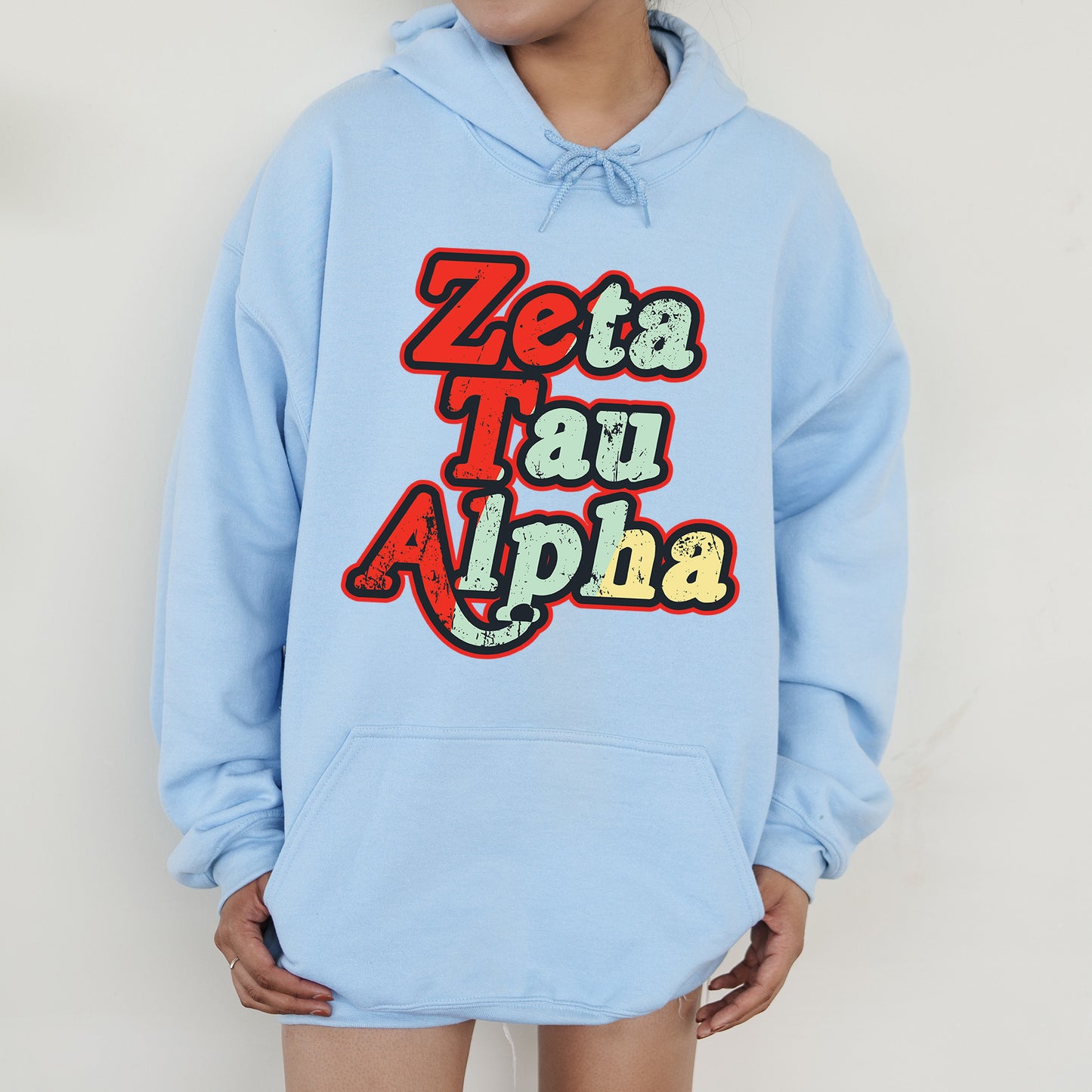 a person wearing a blue hoodie that says zeta tau alpha