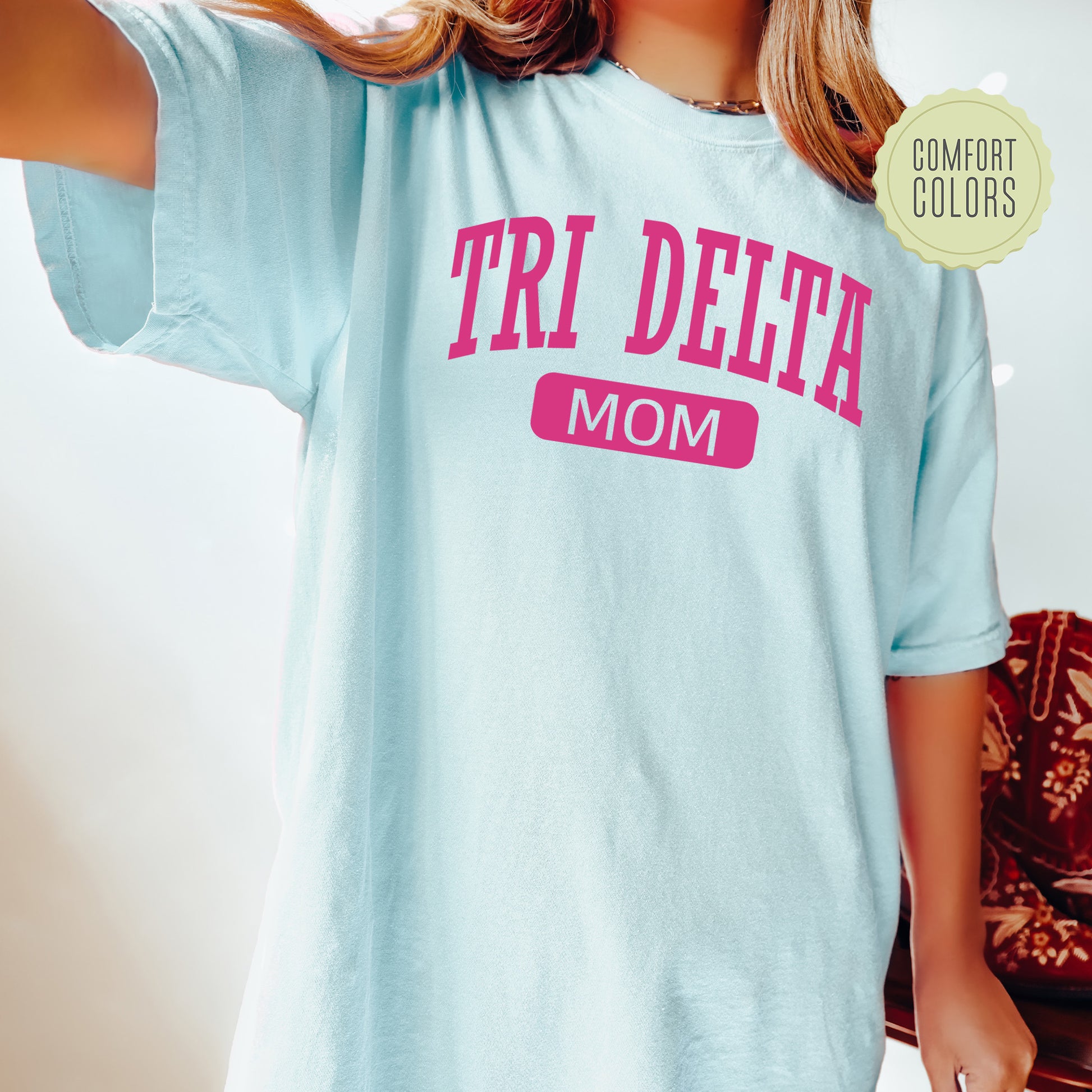 a woman wearing a t - shirt that says tri delta mom
