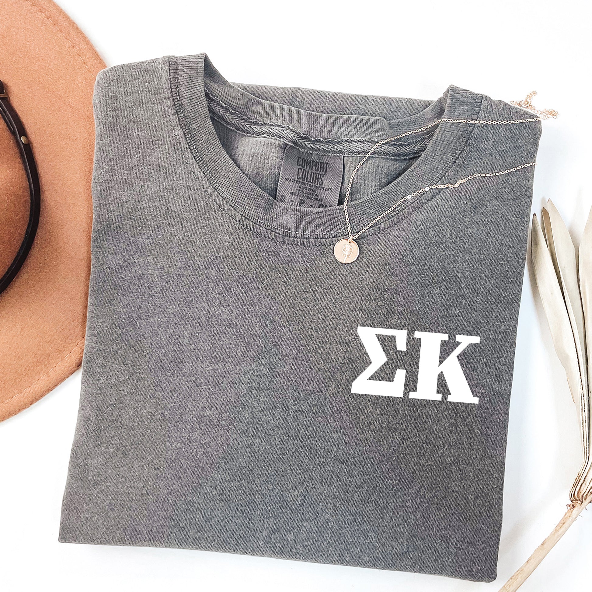 a hat, sunglasses, and t - shirt on a white surface