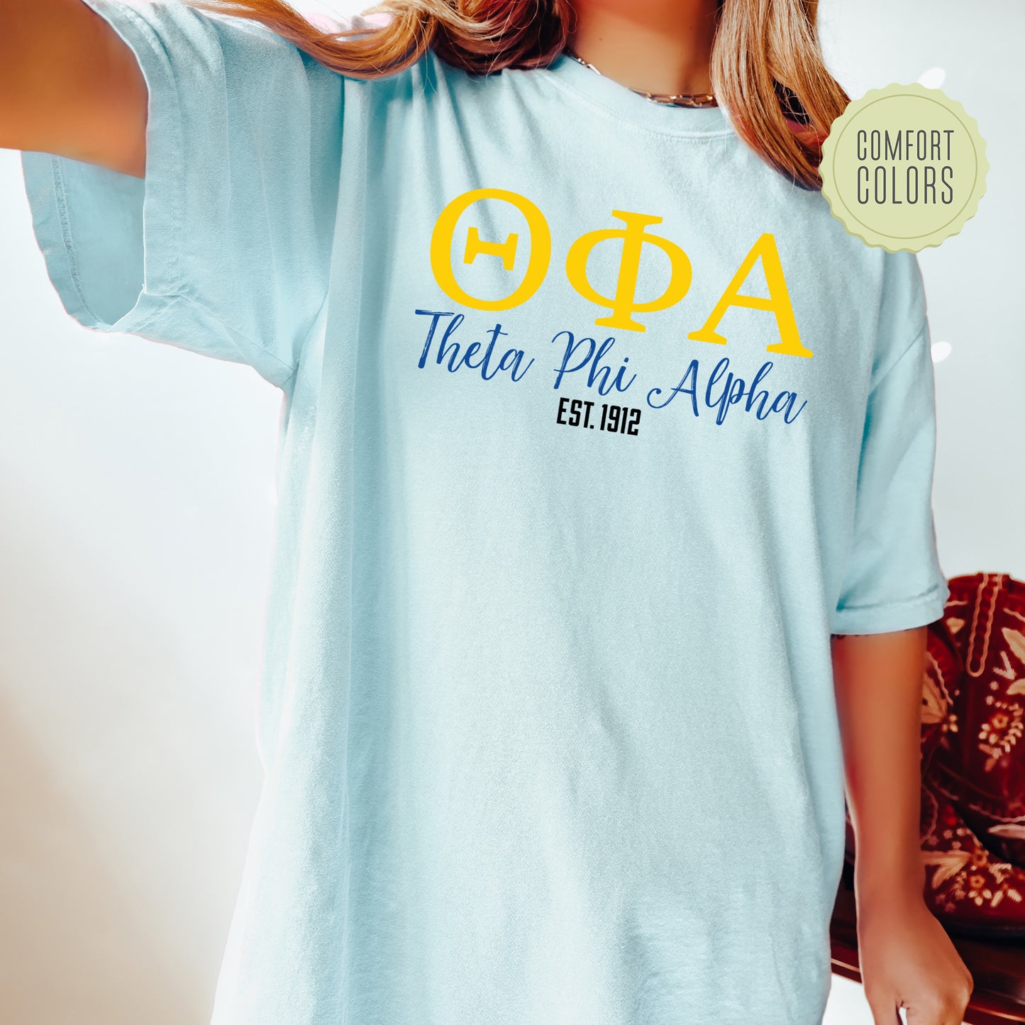 a woman wearing a blue t - shirt with a yellow phi phi phi phi phi